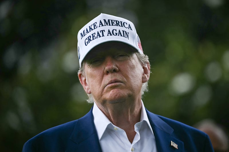 TOPSHOT - US President Donald Trump speaks to the press as workers install a large flag pole on the South Lawn of the White House in Washington, DC on June 18, 2025. President Trump left the question of whether the United States will join Israeli strikes on Iran up in the air Wednesday, as he said that Tehran had reached out to seek negotiations.