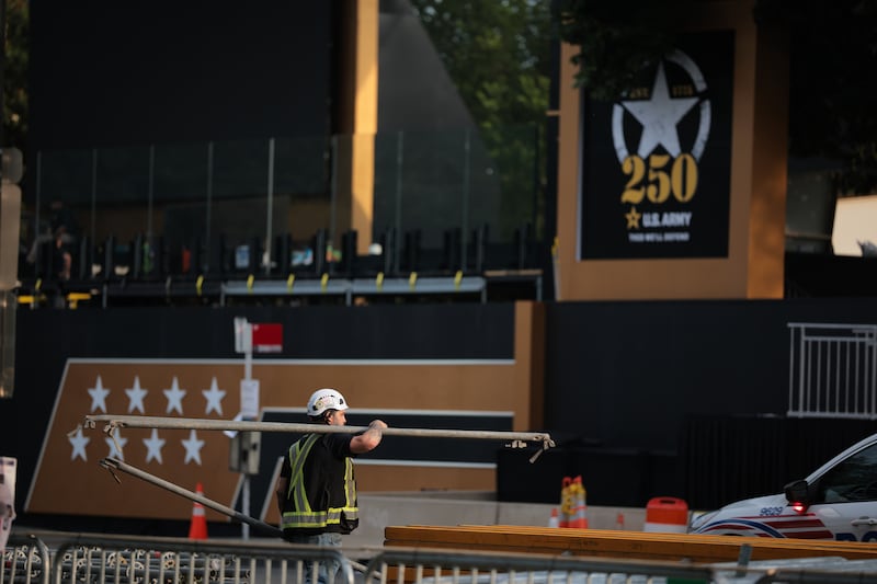 A worker helps build the main riser ahead of the Army's 250th anniversary parade and celebration around the National Mall on June 13, 2025.