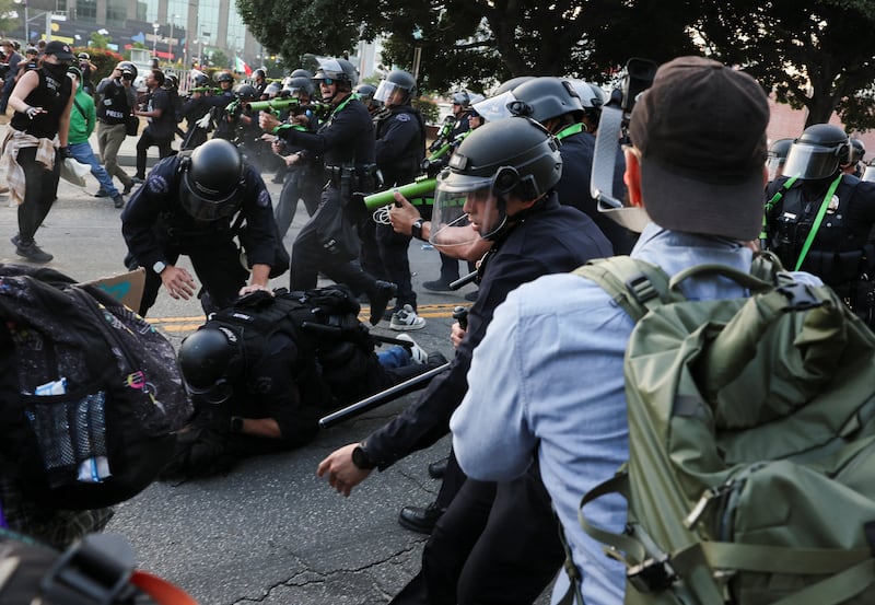 Police officers detain a demonstrator, during protests against federal immigration sweeps, in Los Angeles, California