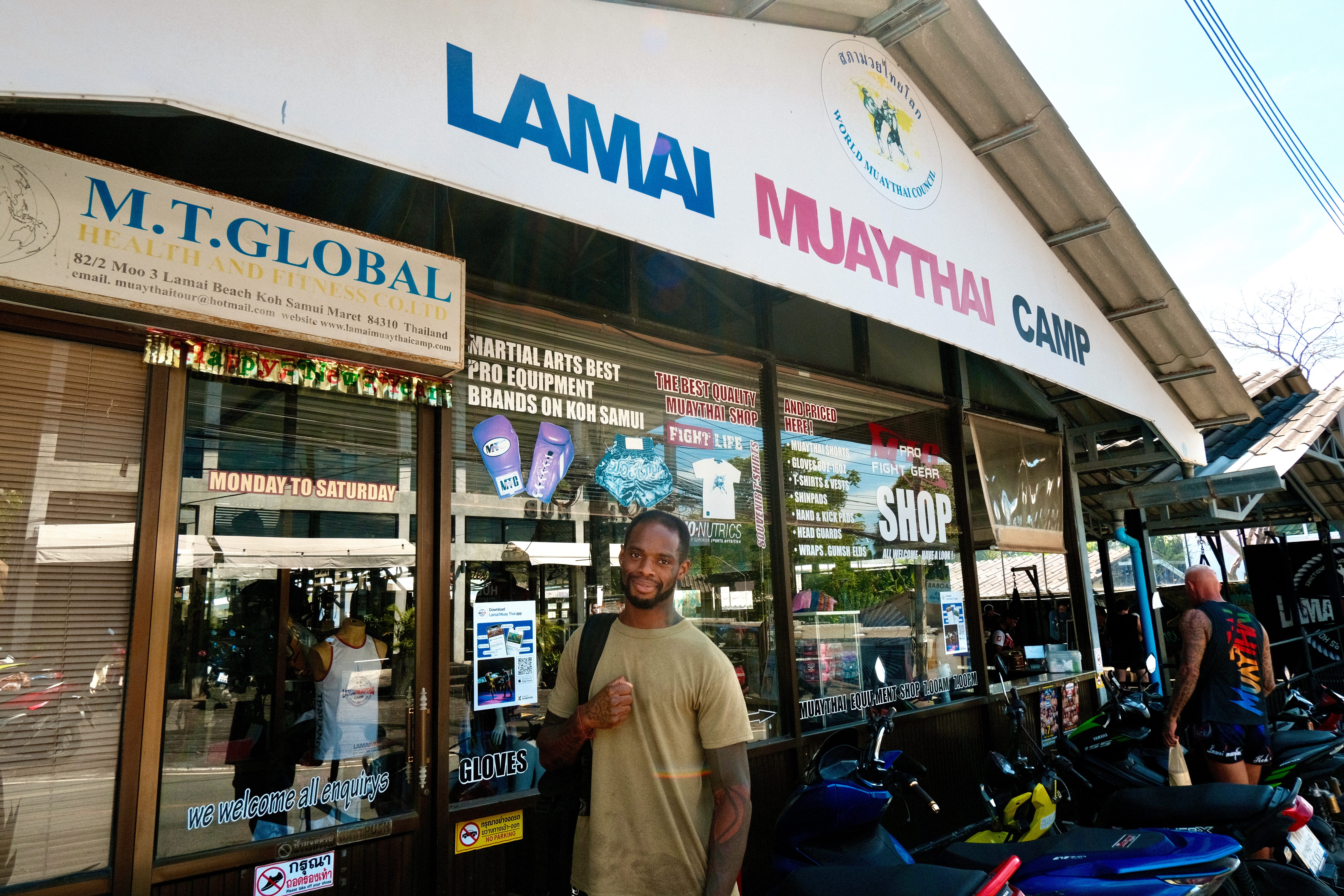 A man standing in front of a Muay Thai gym in Koh Samui, Thailand.