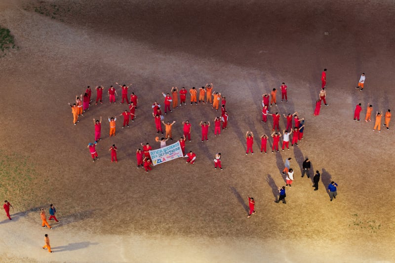 ICE detainees form an S.O.S. in the courtyard at the Bluebonnet Detention Center in Anson, Texas. Their banner reads in part, “We are not terrorists.”
