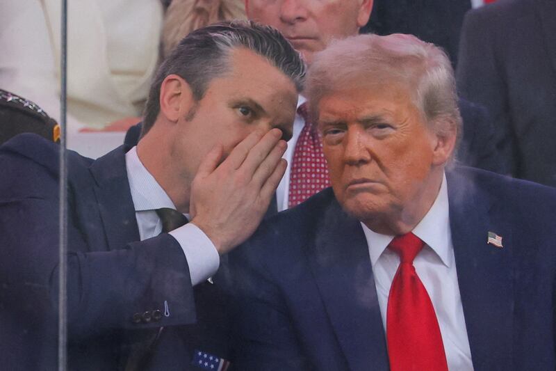 U.S. Secretary of Defense Pete Hegseth talks to U.S. President Donald Trump during the U.S. Army's 250th Birthday parade, on the same day of U.S. President Donald Trump 79th birthday, in Washington, D.C., U.S., June 14, 2025. REUTERS/Carlos Barria     TPX IMAGES OF THE DAY