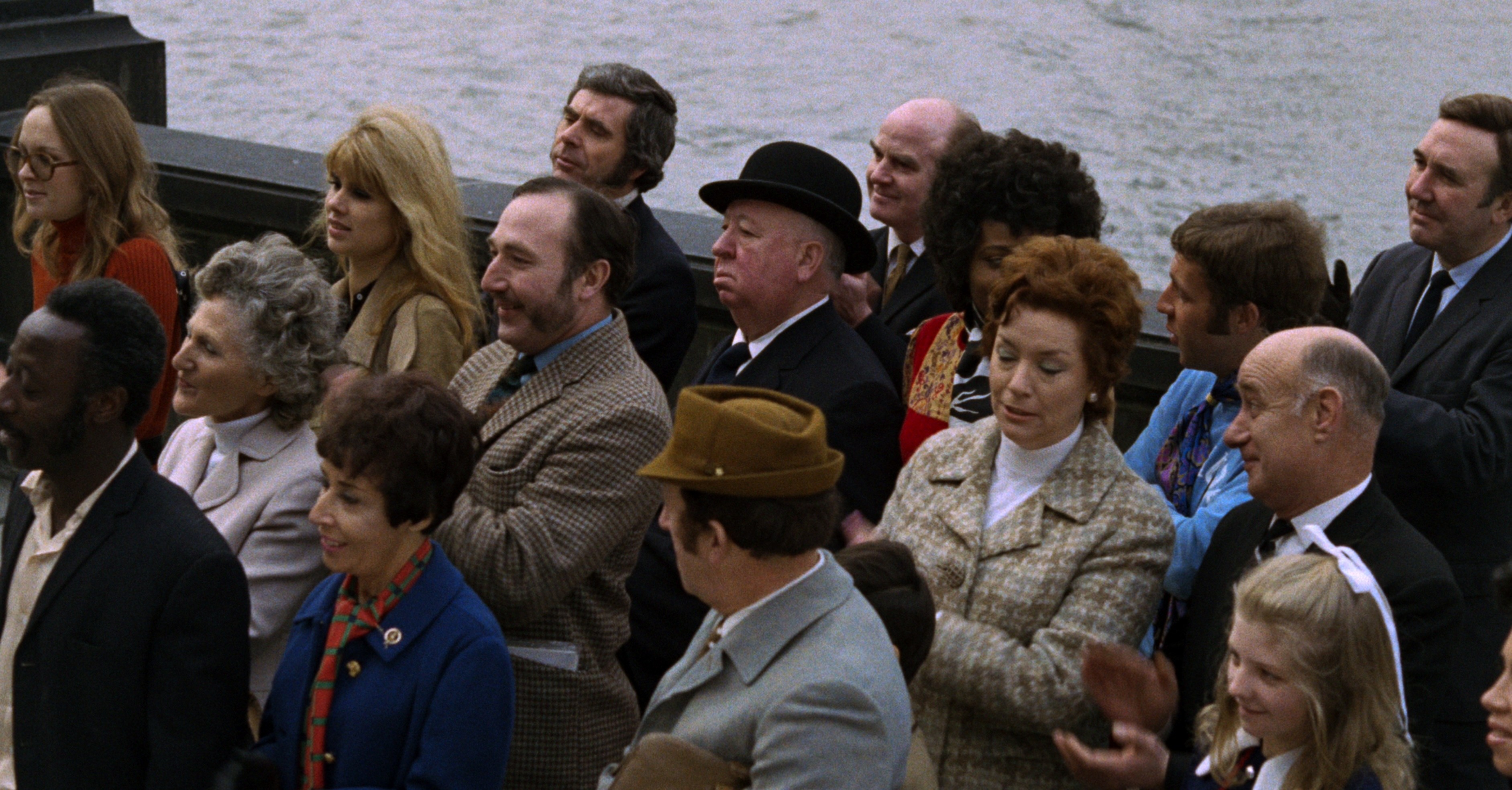 A crowd of people stand on a pier in Frenzy