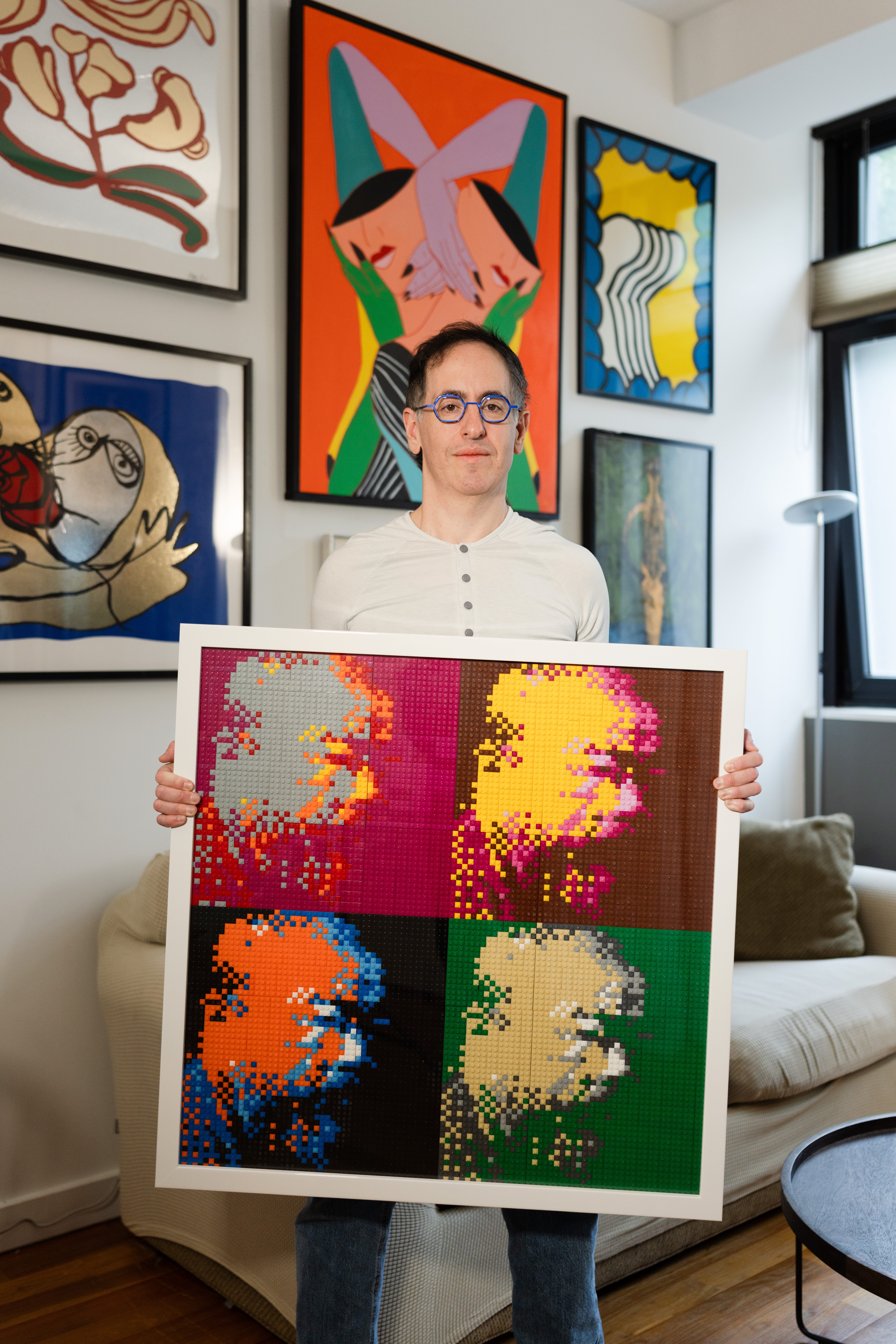 Albert Fox holds a painting in his living room
