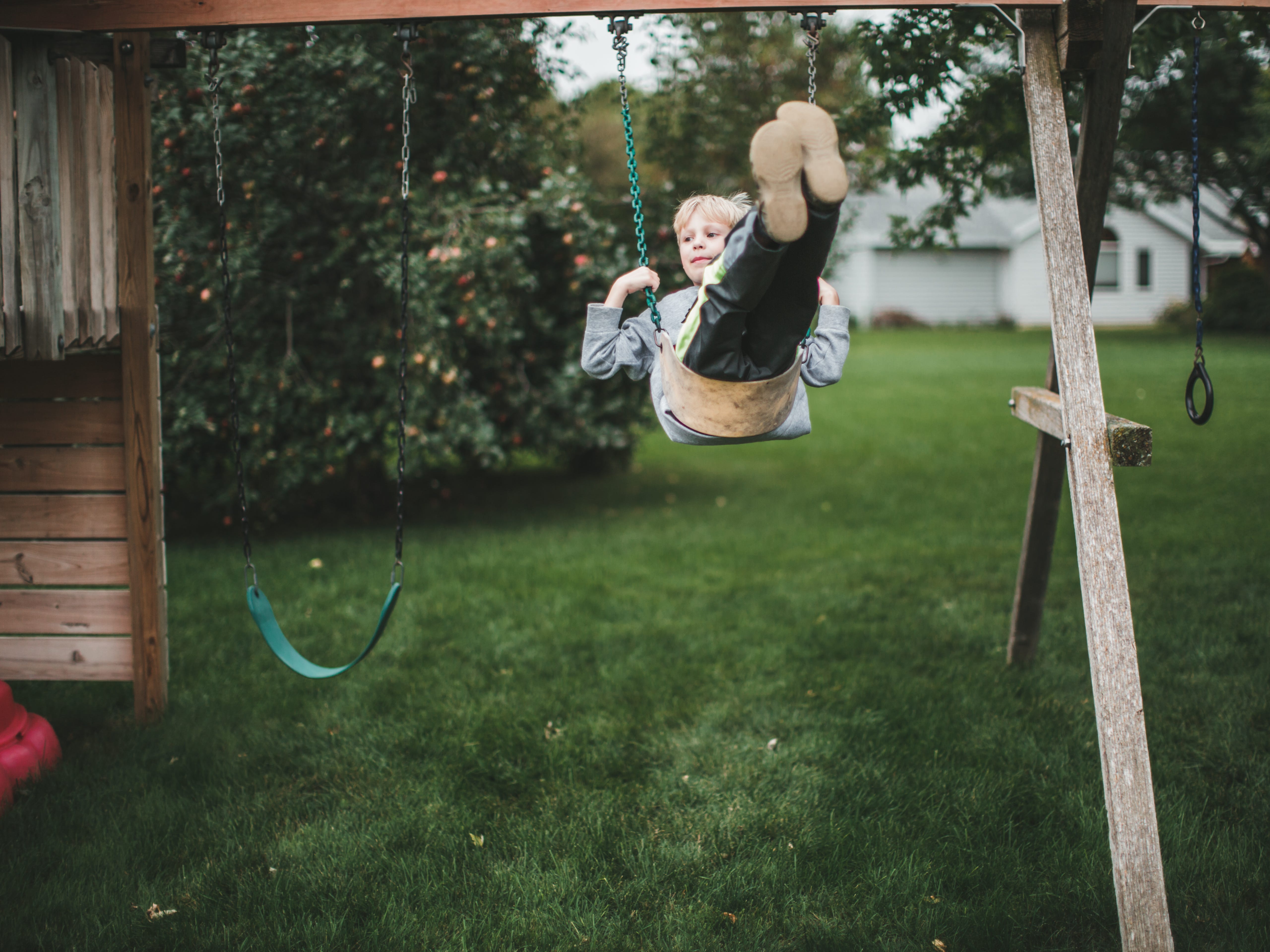 a kids on a swing in a backyard