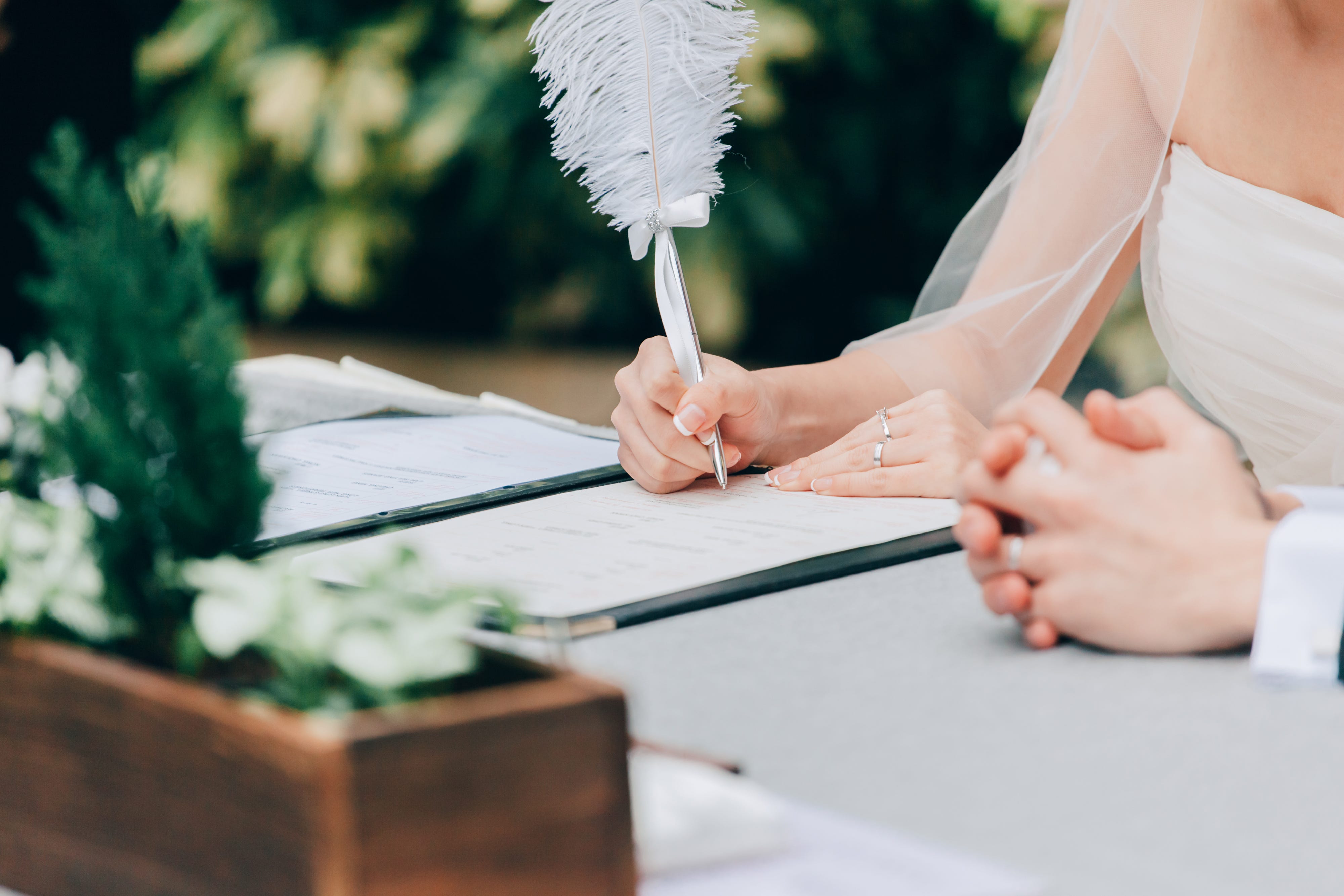 Bride signing marriage certificate on her wedding ceremony