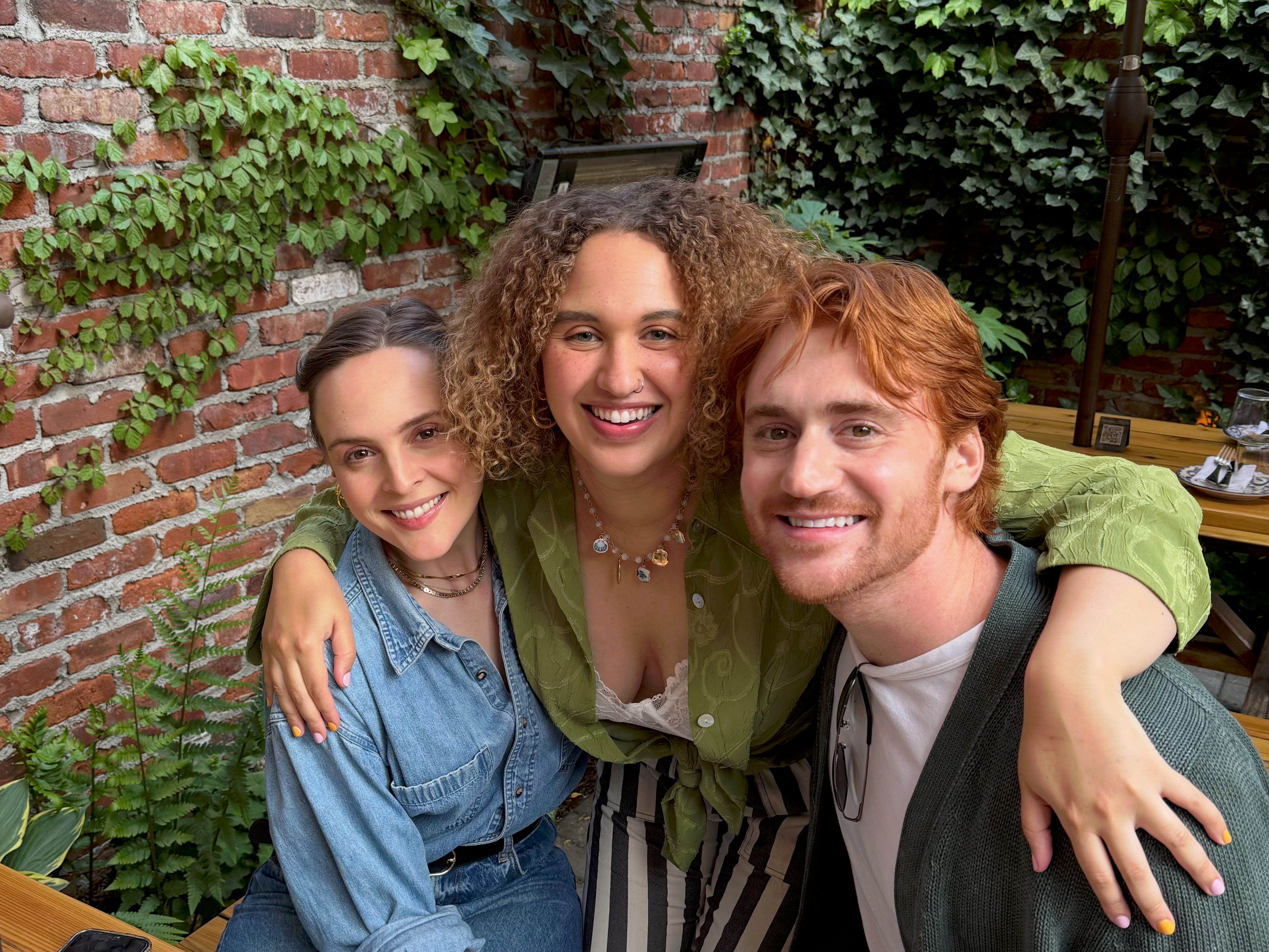 The author (center) posing with two friends at a restaurant in Brooklyn.