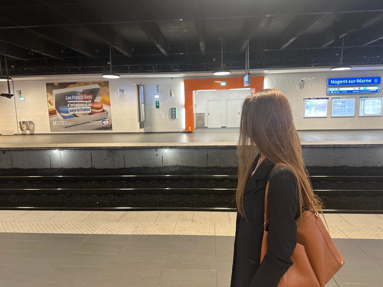 Author Grace Brennan looking at train tracks at a metro in France