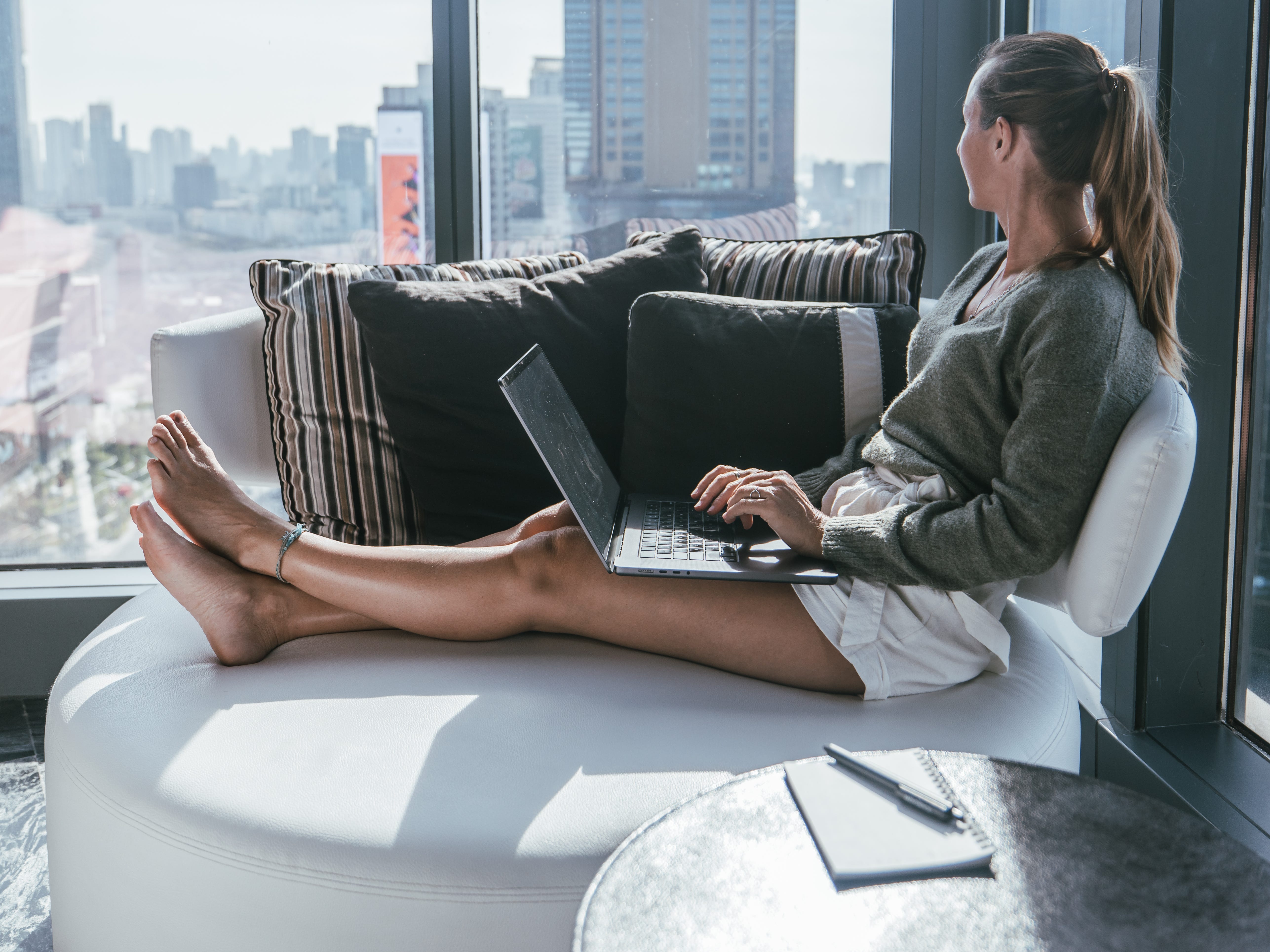 a woman sitting on a couch with a laptop in her lap