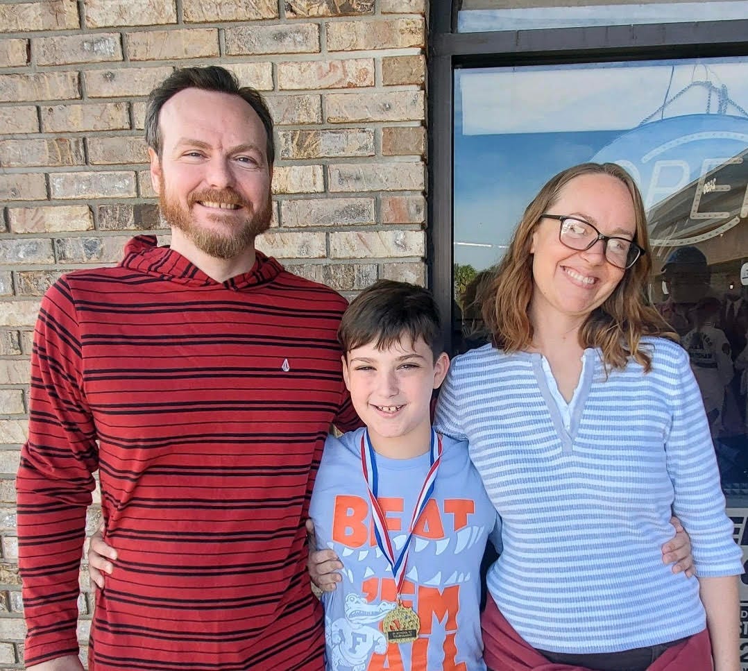 Author Ashley Archambault, partner, and son smiling