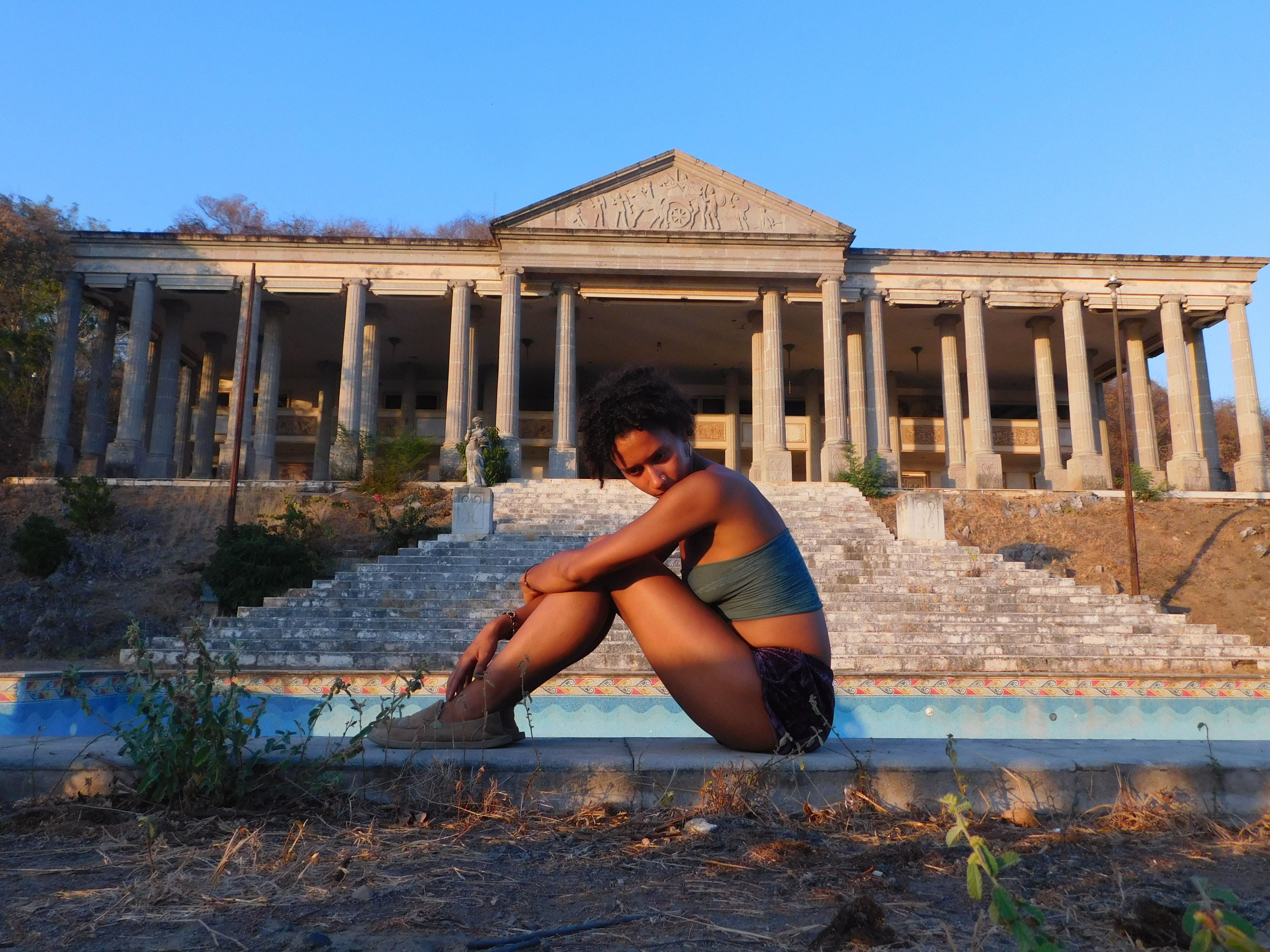 The author sitting on the ground in front of the Zihuatanejo Parthenon.