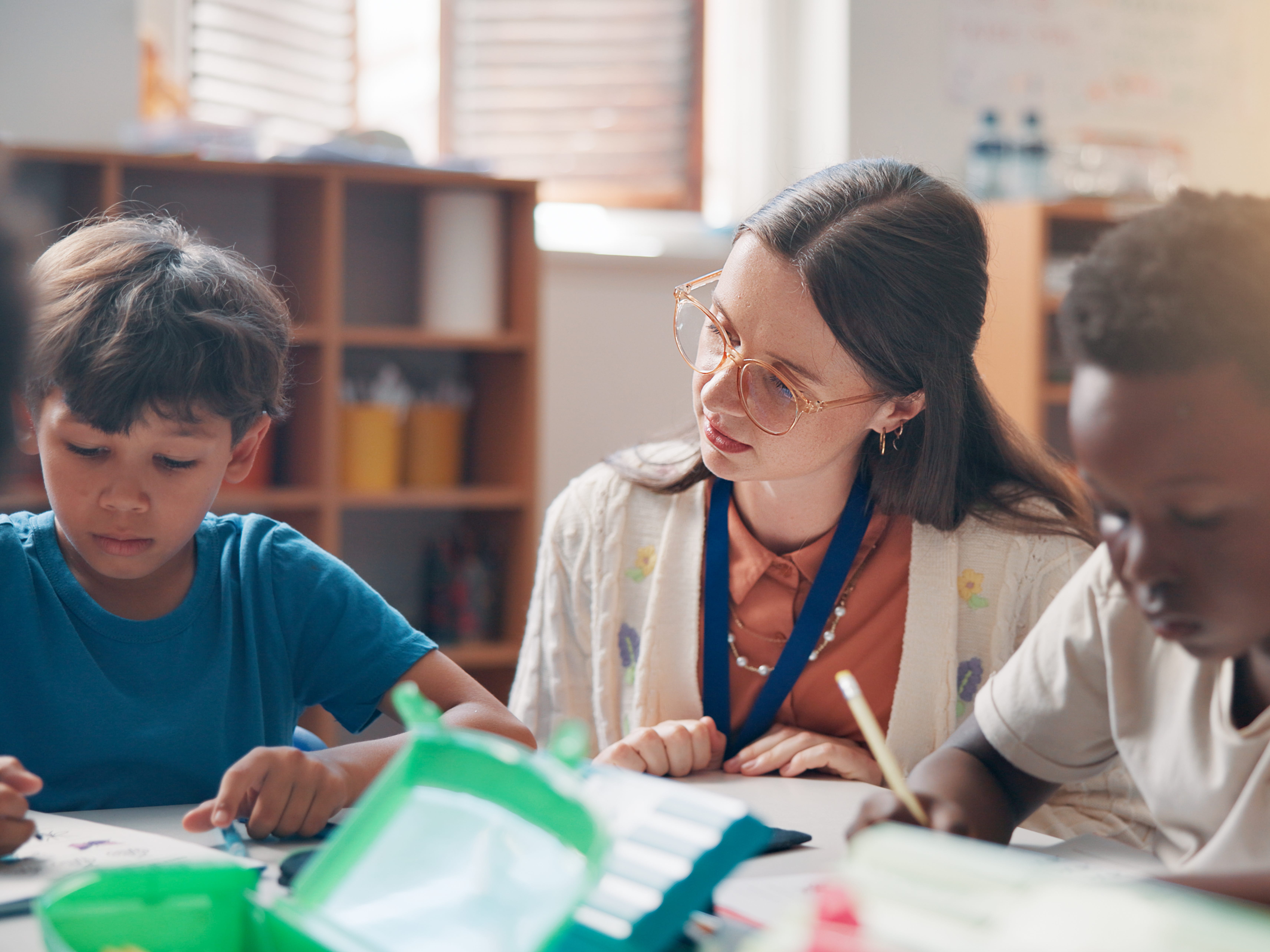 a teacher sitting between two students