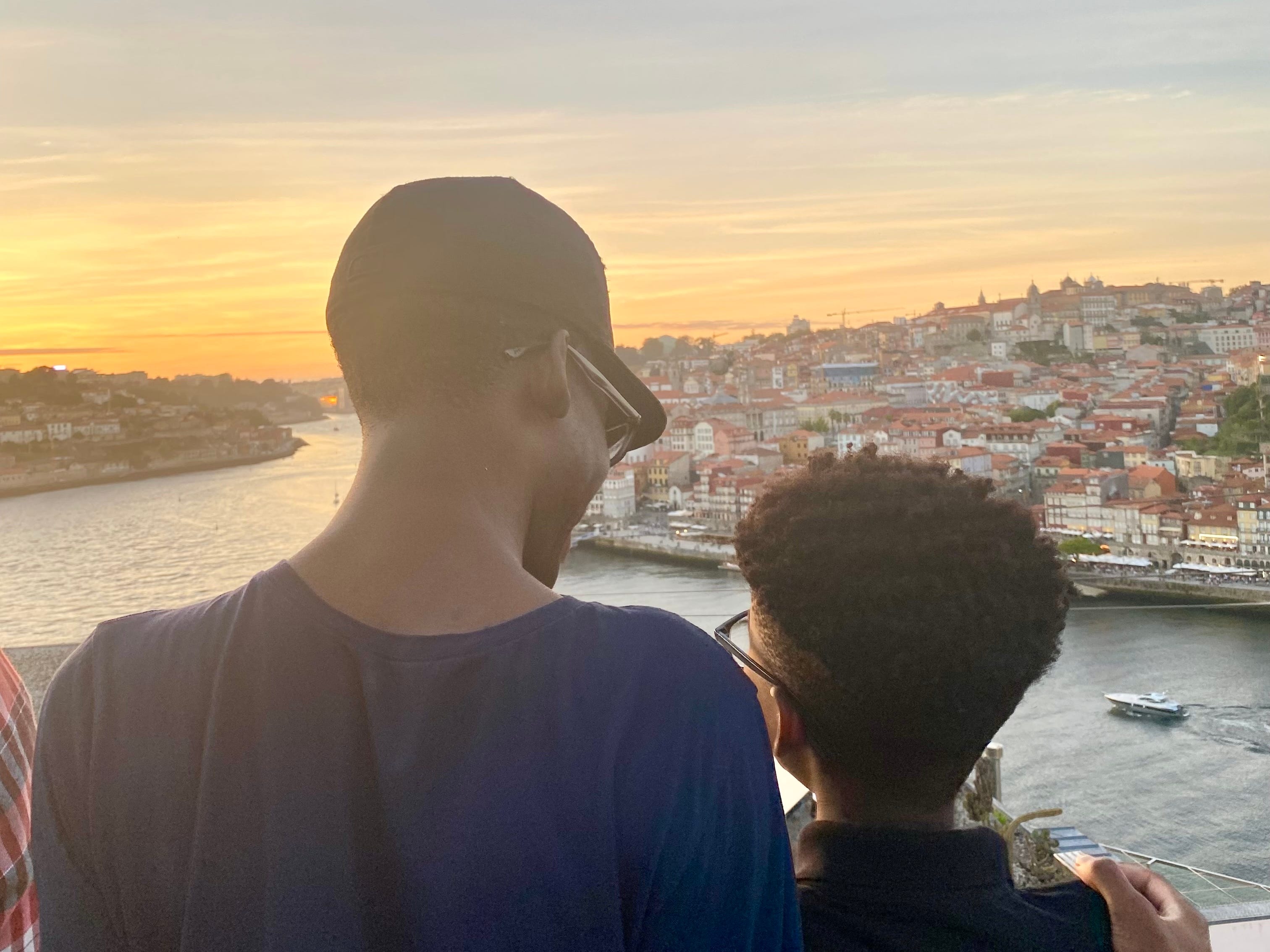 The author's two sons watching a sunset in Portugal over a bay view.