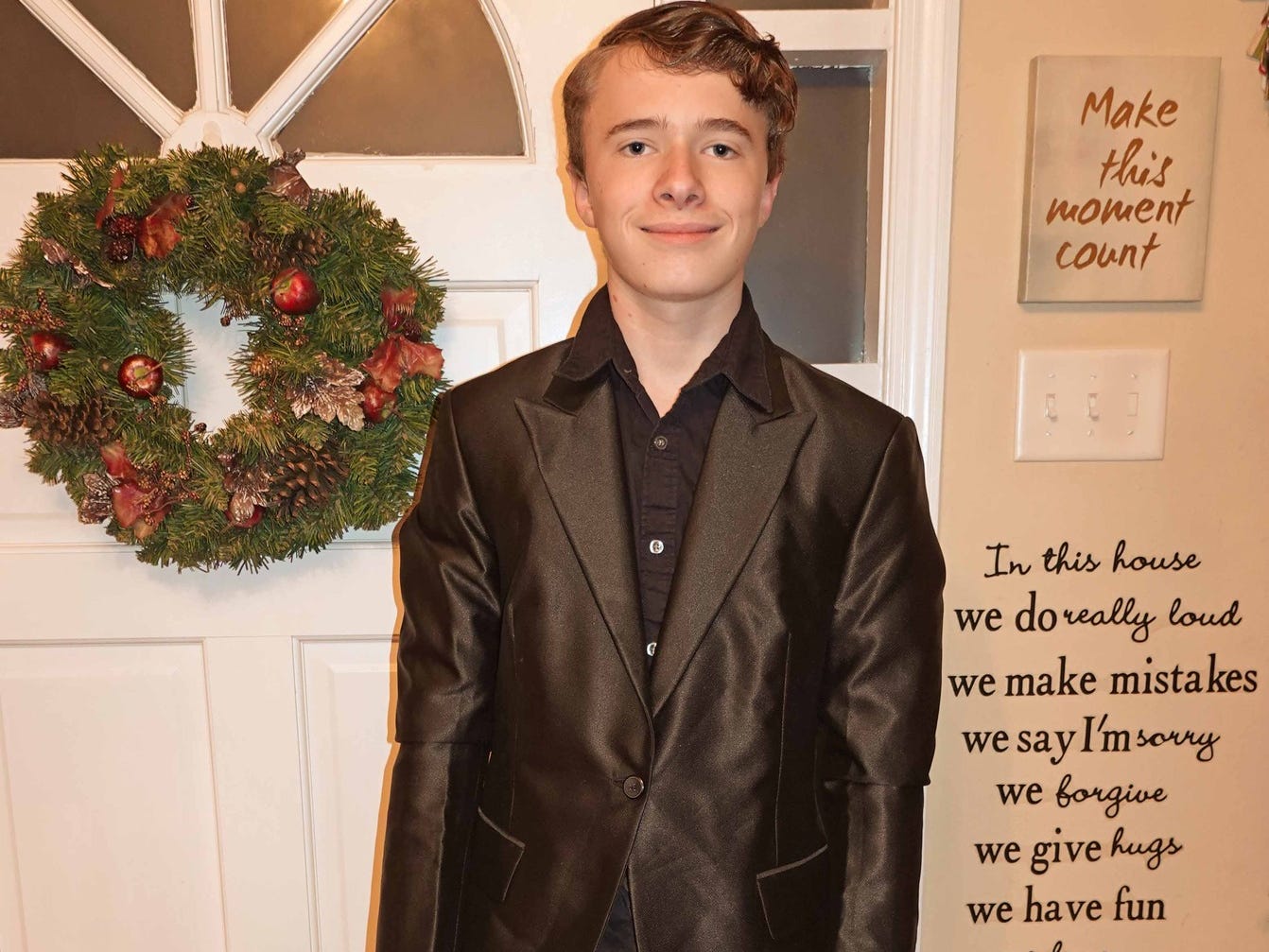 a young kid in a black tux