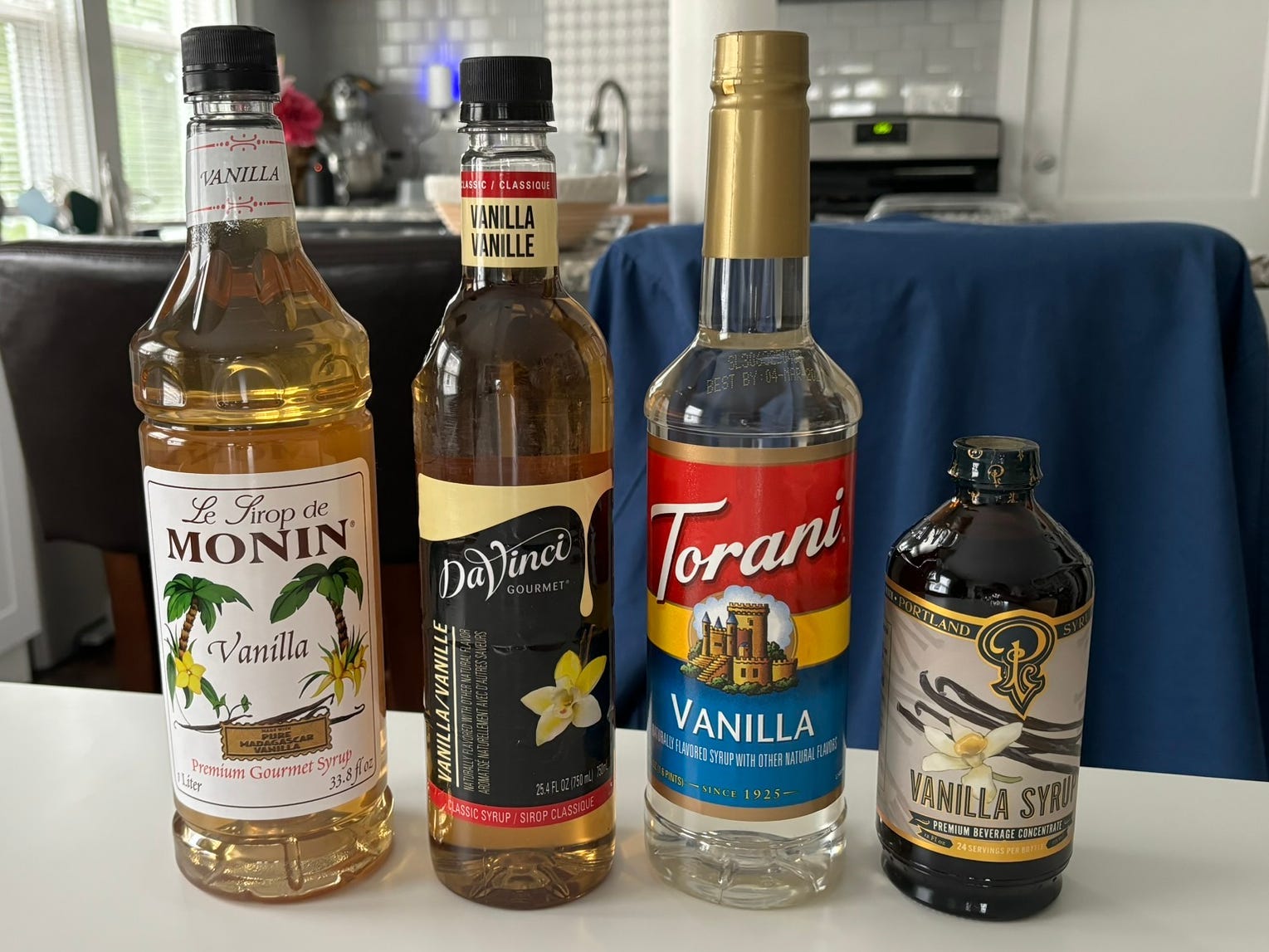 Four different vanilla coffee syrups sitting next to each other on a counter