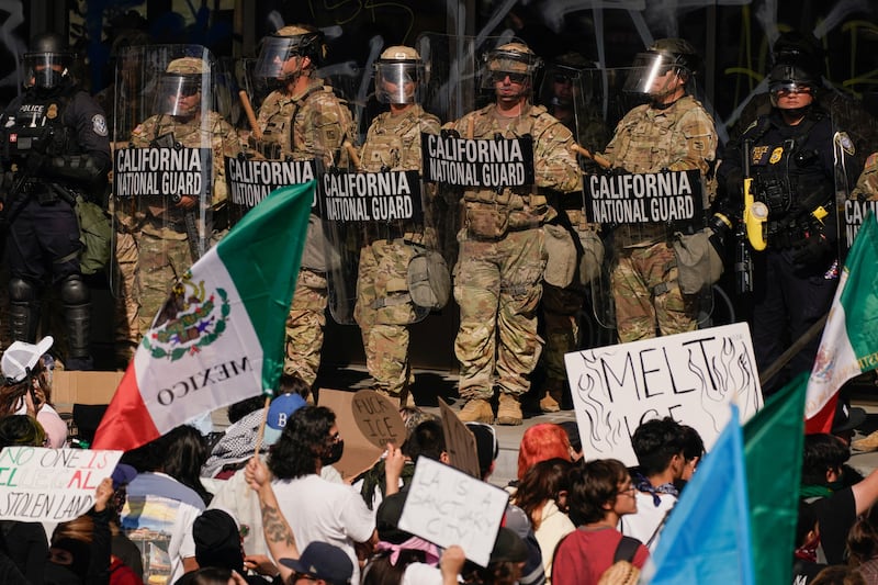 California National Guard troops and police officers stand guard as people attend a rally against federal immigration sweeps, in Los Angeles, California, U.S. June 9, 2025. REUTERS/David Ryder