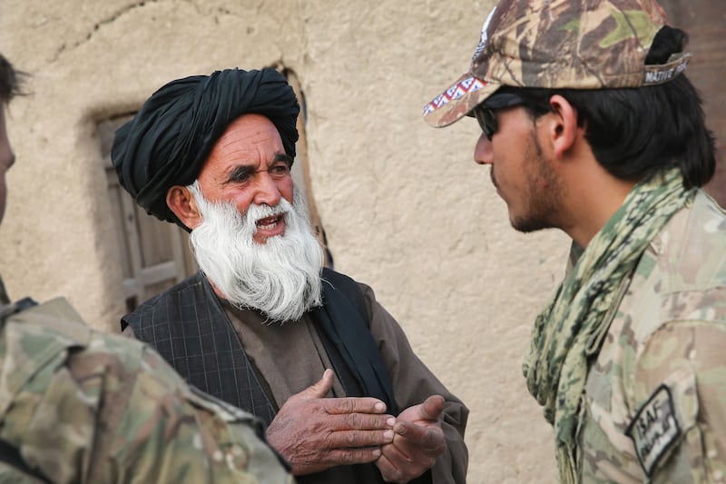 An Afghan interpreter with the U.S. Army's 4th Squadron 2d Cavalry Regiment helps to question a villager during a joint patrol with soldiers from the Afghan National Army in 2014.