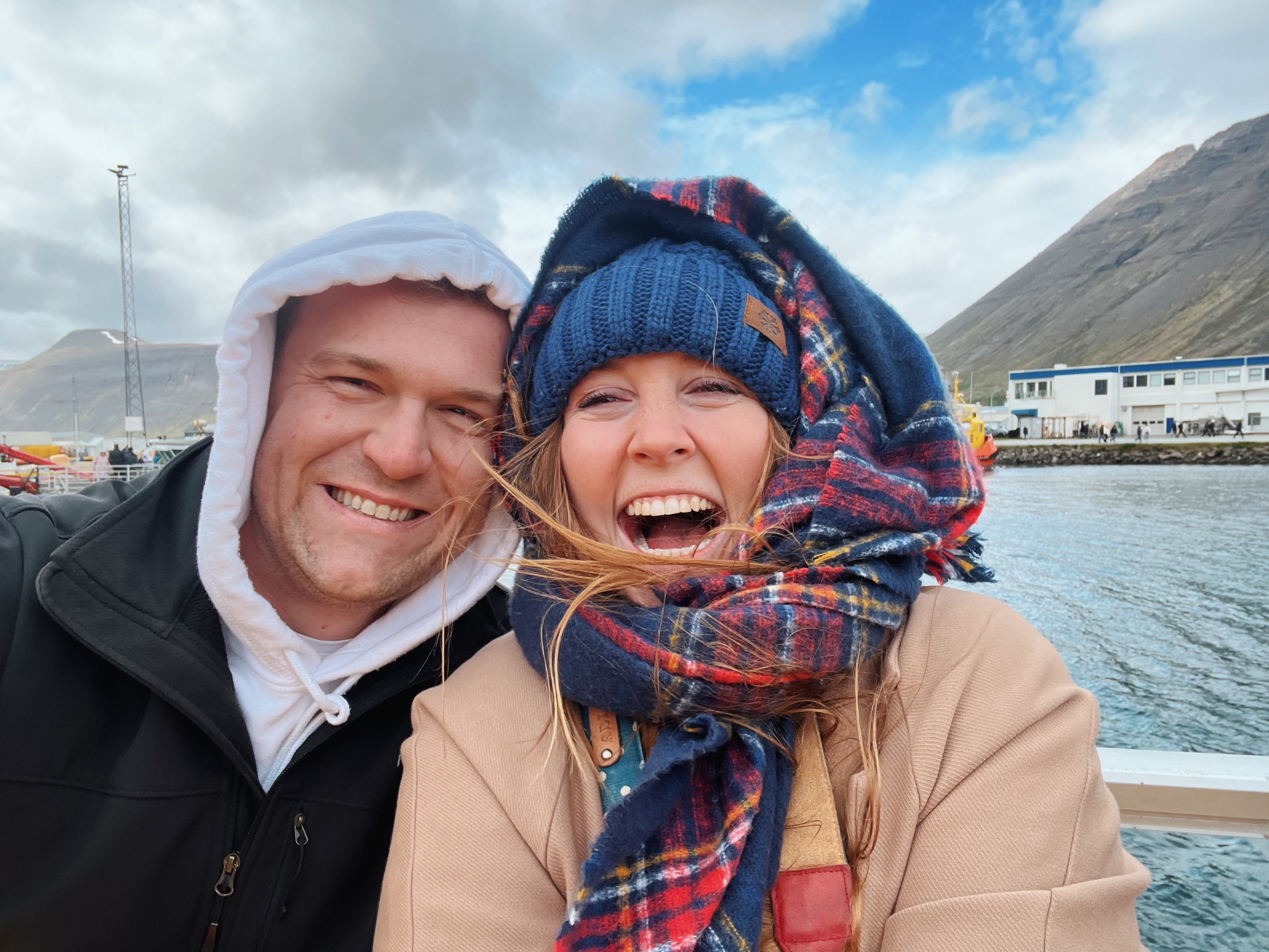 Author Allie Hubers and her husband smiling with hoods on in Iceland on a boat