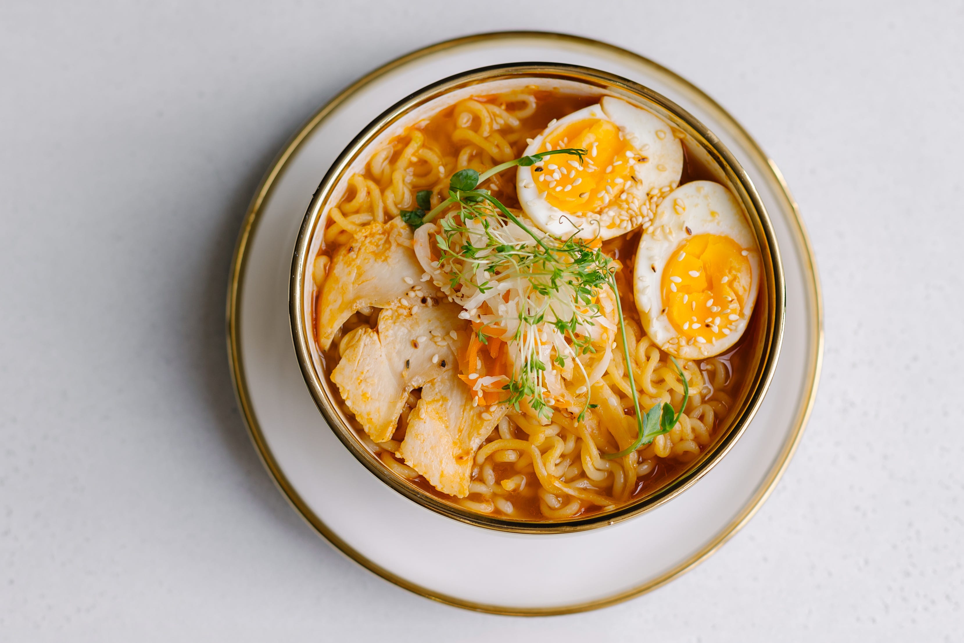 Bowl of ramen with eggs and green garnish