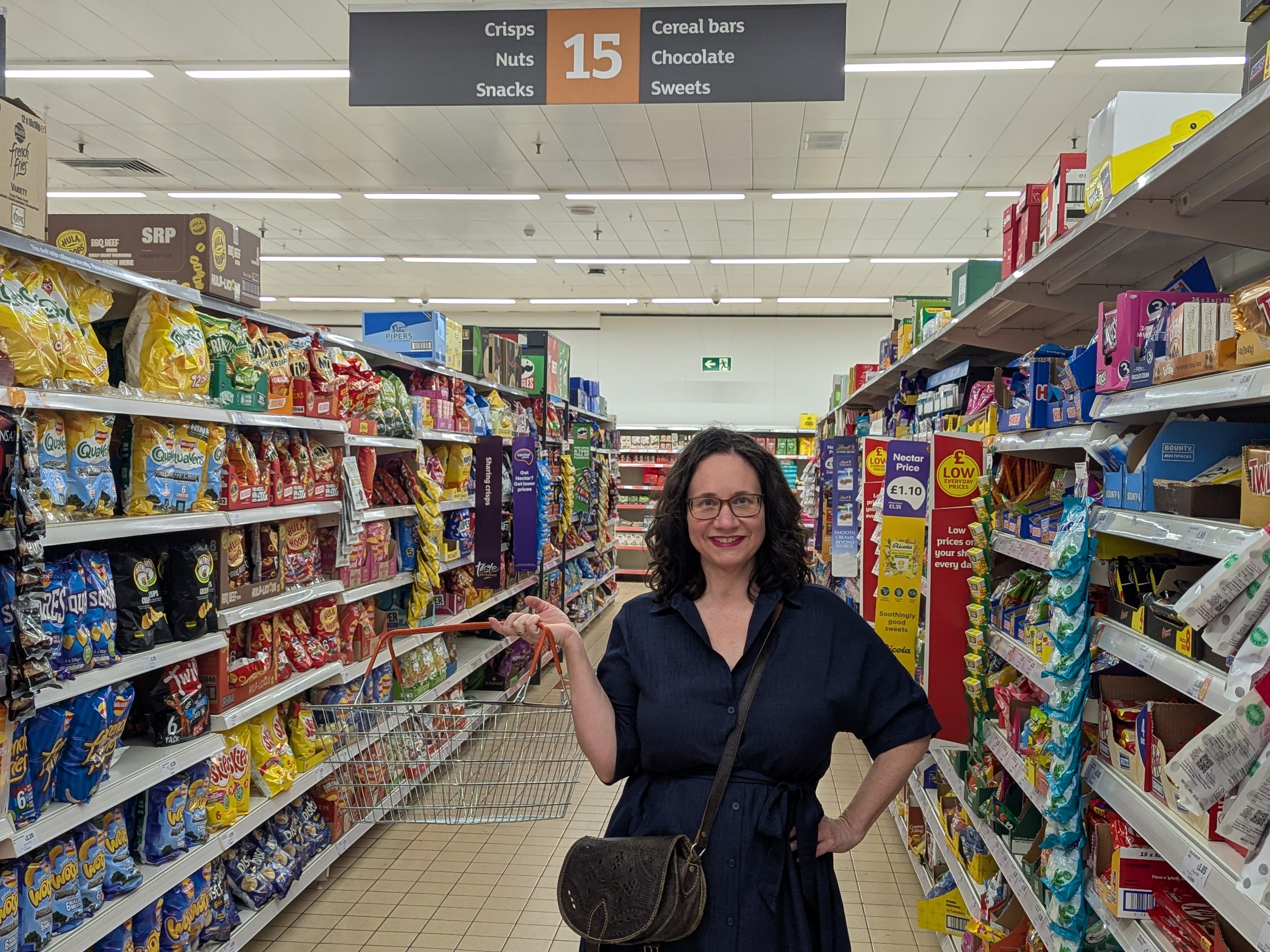 The author posing in a Sainsbury's aisle with an empty shopping basket.