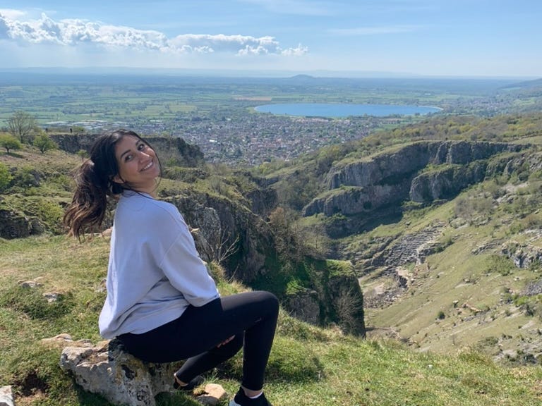 The writer, who recently moved to England, poses in front of the Cheddar Gorge in the UK.