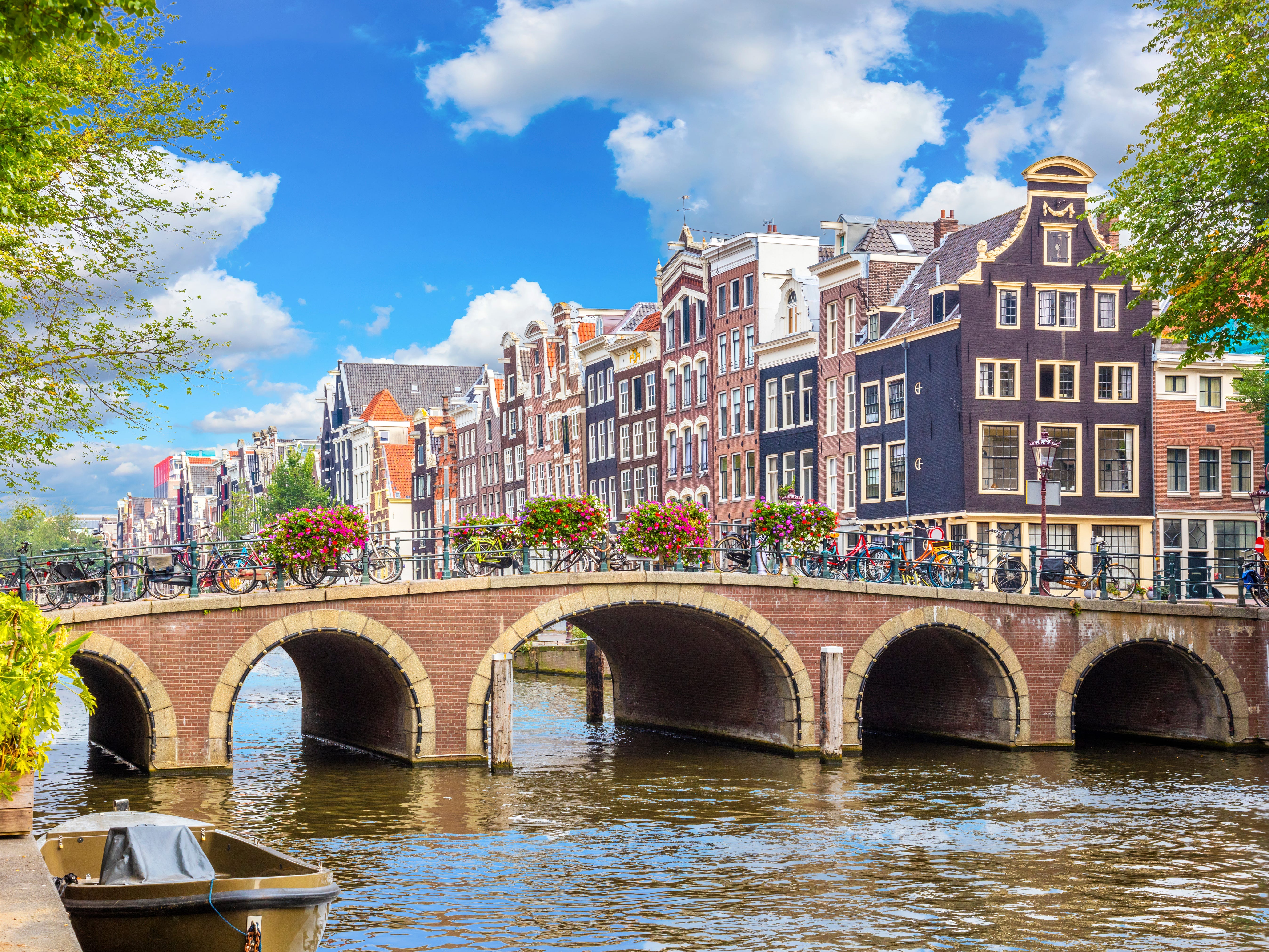 Buildings behind a bridge with five openings along a canal in Amsterdam.