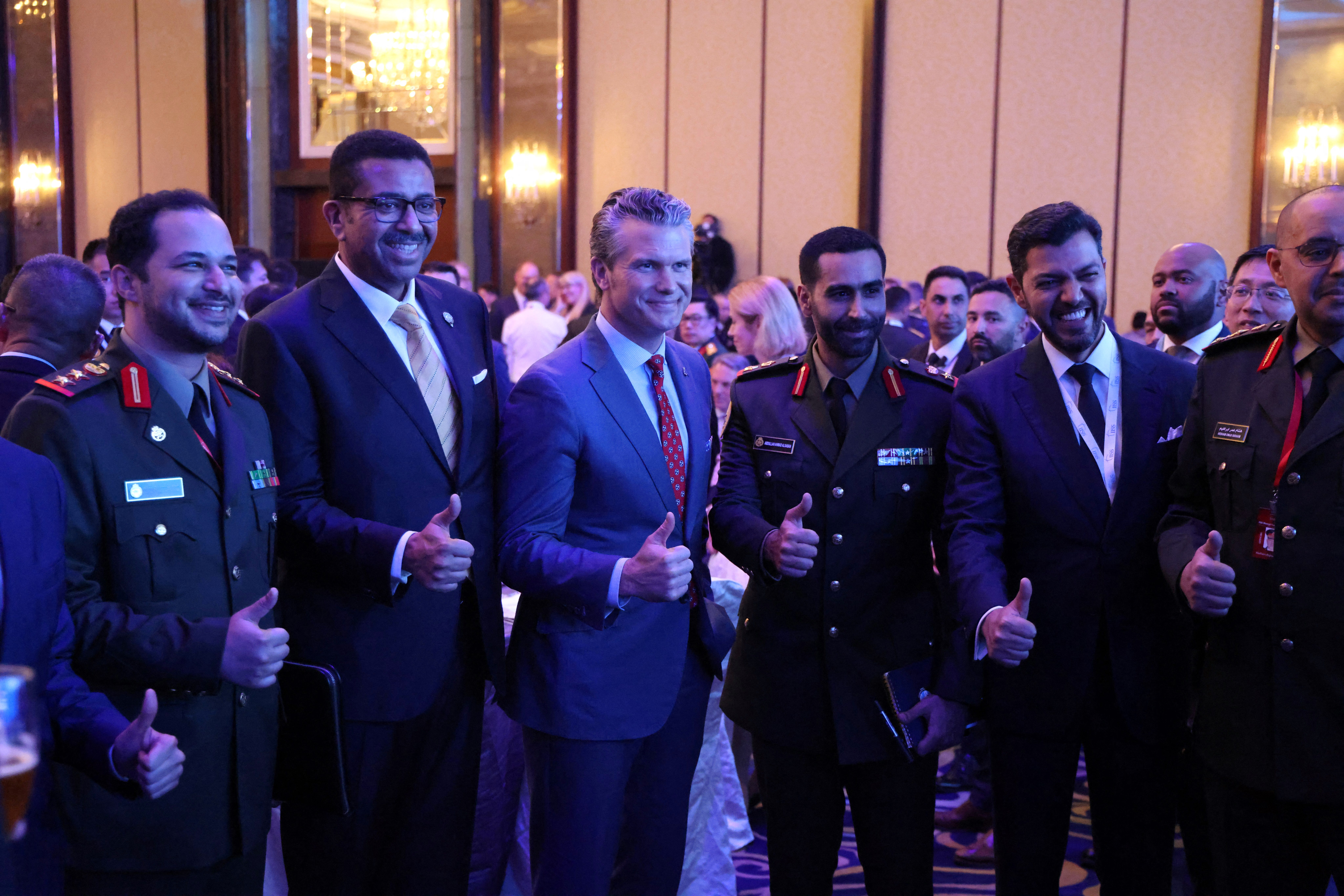 Hegseth and several military officers pose with a thumbs-up.