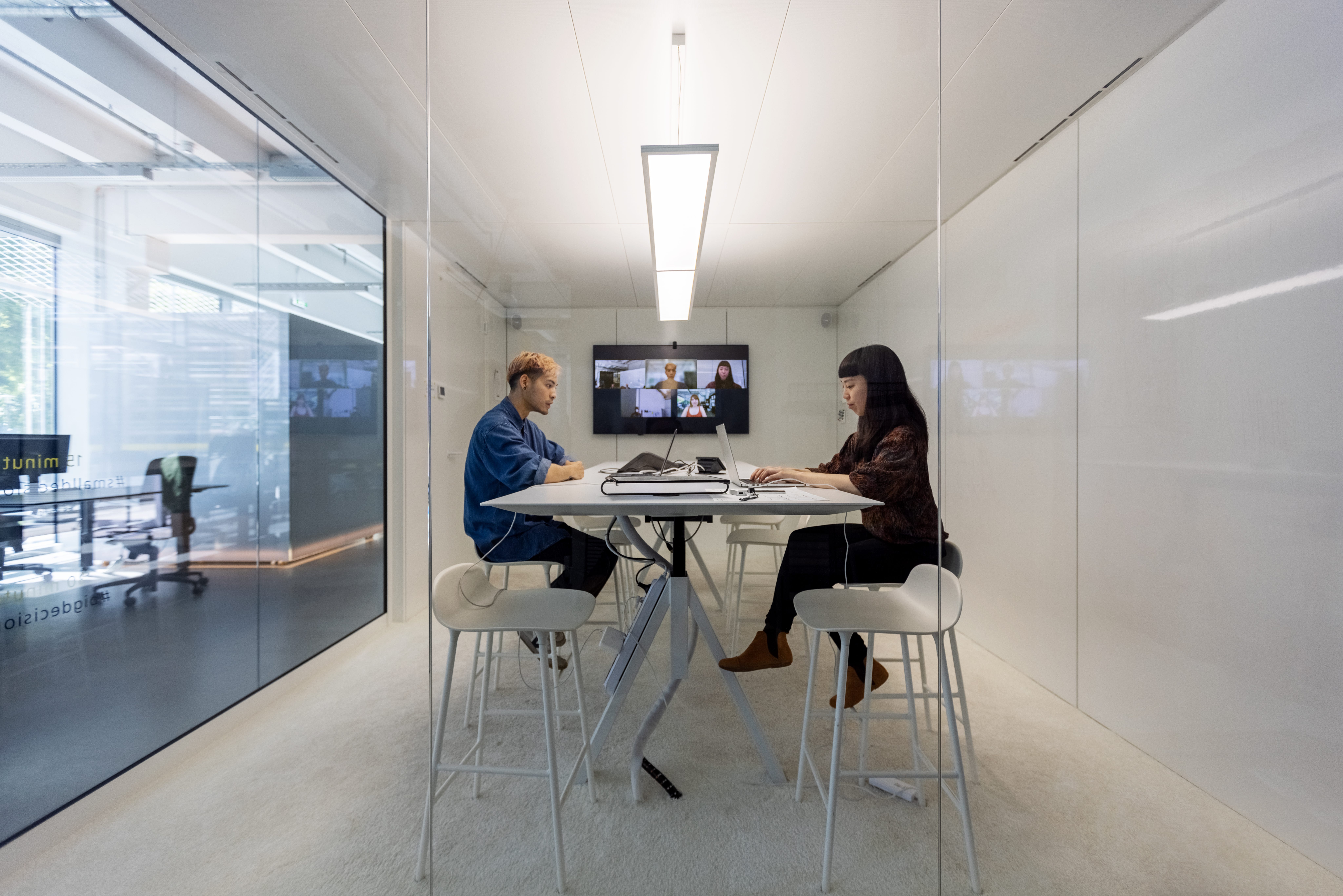 Man and woman working in hybrid office cubicle