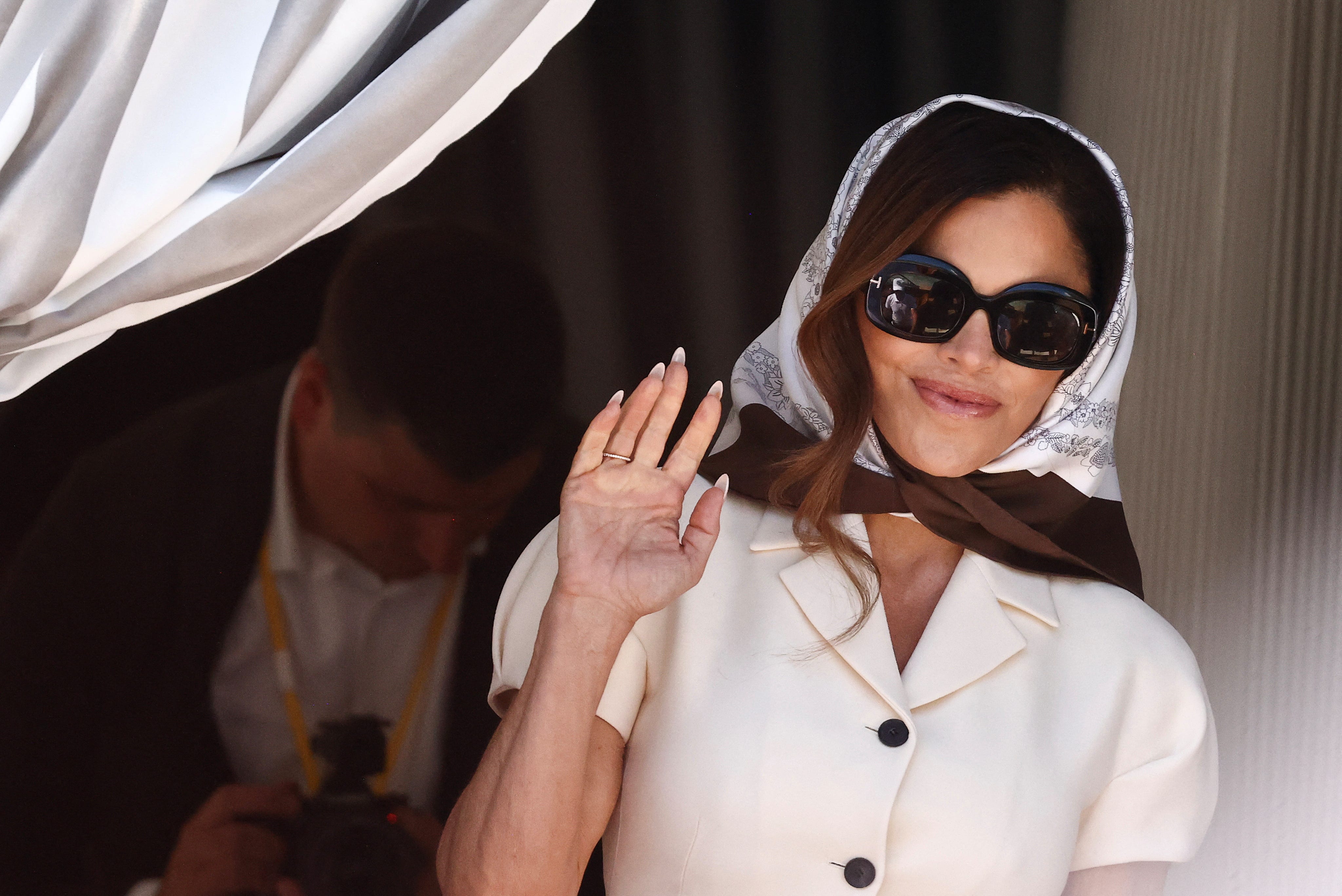 Lauren Sánchez waves at photographers in Venice.