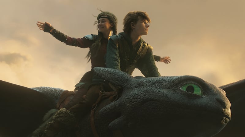 Nico Parker and Mason Thames riding Toothless, in Universal Pictures’ live-action How to Train Your Dragon.