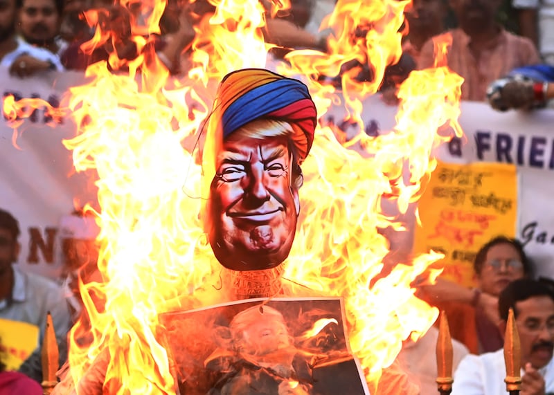 Members of India's main opposition party, the National Congress, burn an effigy of U.S. President Donald Trump in Kolkata, India, on May 14, 2025. They protest against America's interference in Indian internal affairs and the grouping of India and Pakistan in the same bracket regarding the recent war issue. (Photo by Gautam Bose/NurPhoto via Getty Images)