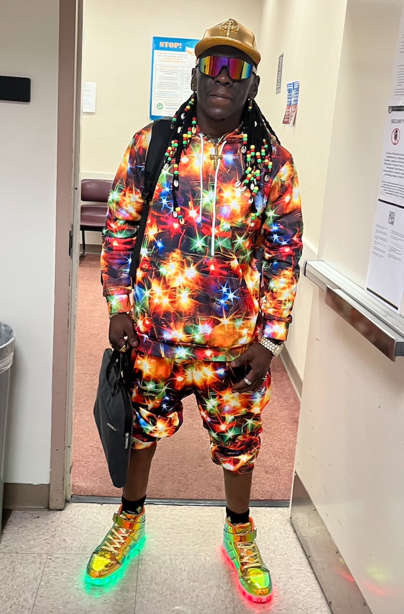A man in a top which apparently has lights, shorts and shoes which appear to be illuminated.