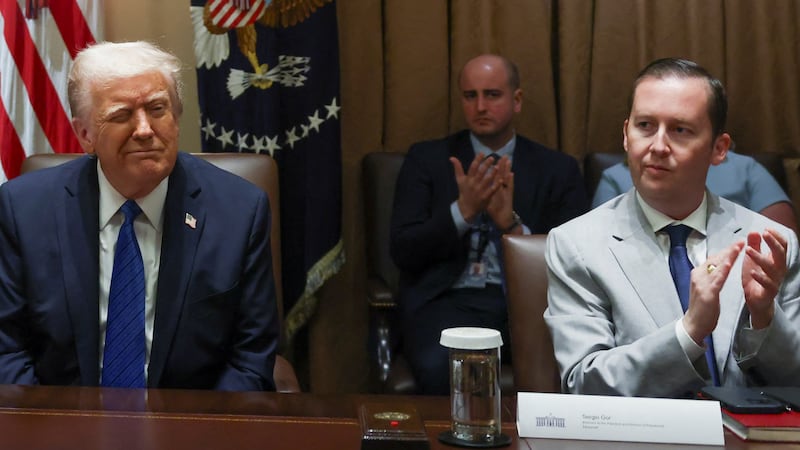 President Donald Trump reacts as Sergio Gor and White House Chief of Staff Susie Wiles sit next to him on the day of a meeting with U.S. ambassadors at the White House on March 25, 2025.