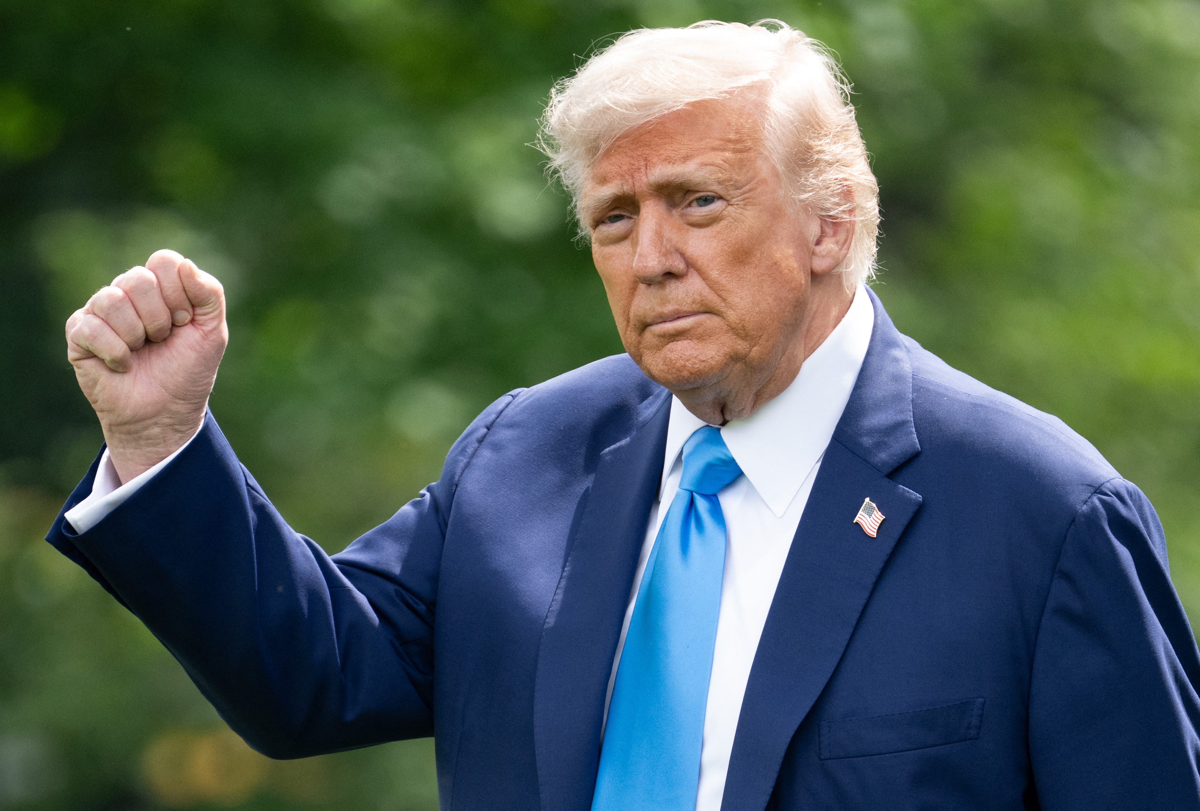 President Donald Trump raising his fist in the air while walking.