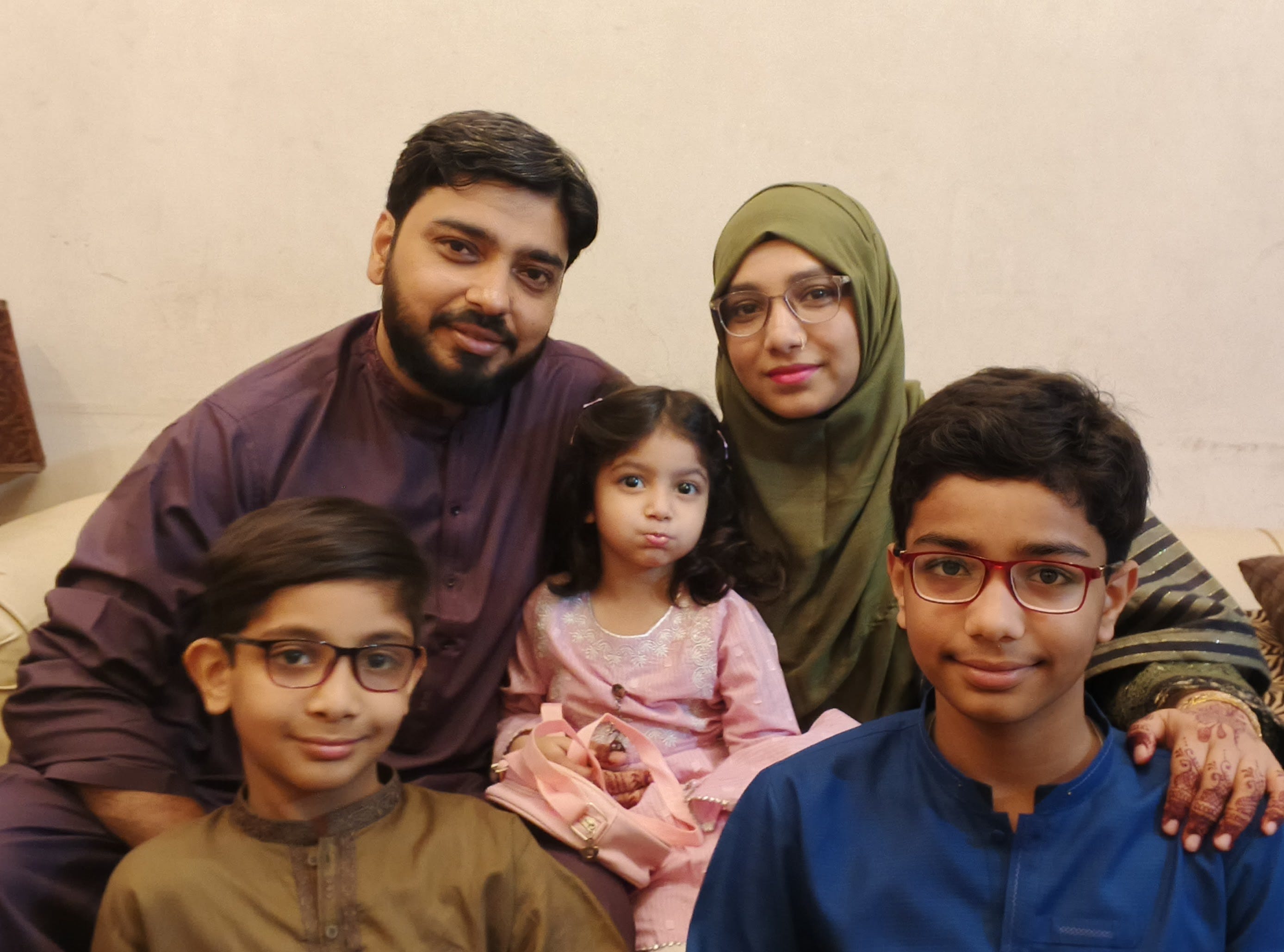 Ariba Mobin (top right) with her husband (left) and three children (front left, right, and center)