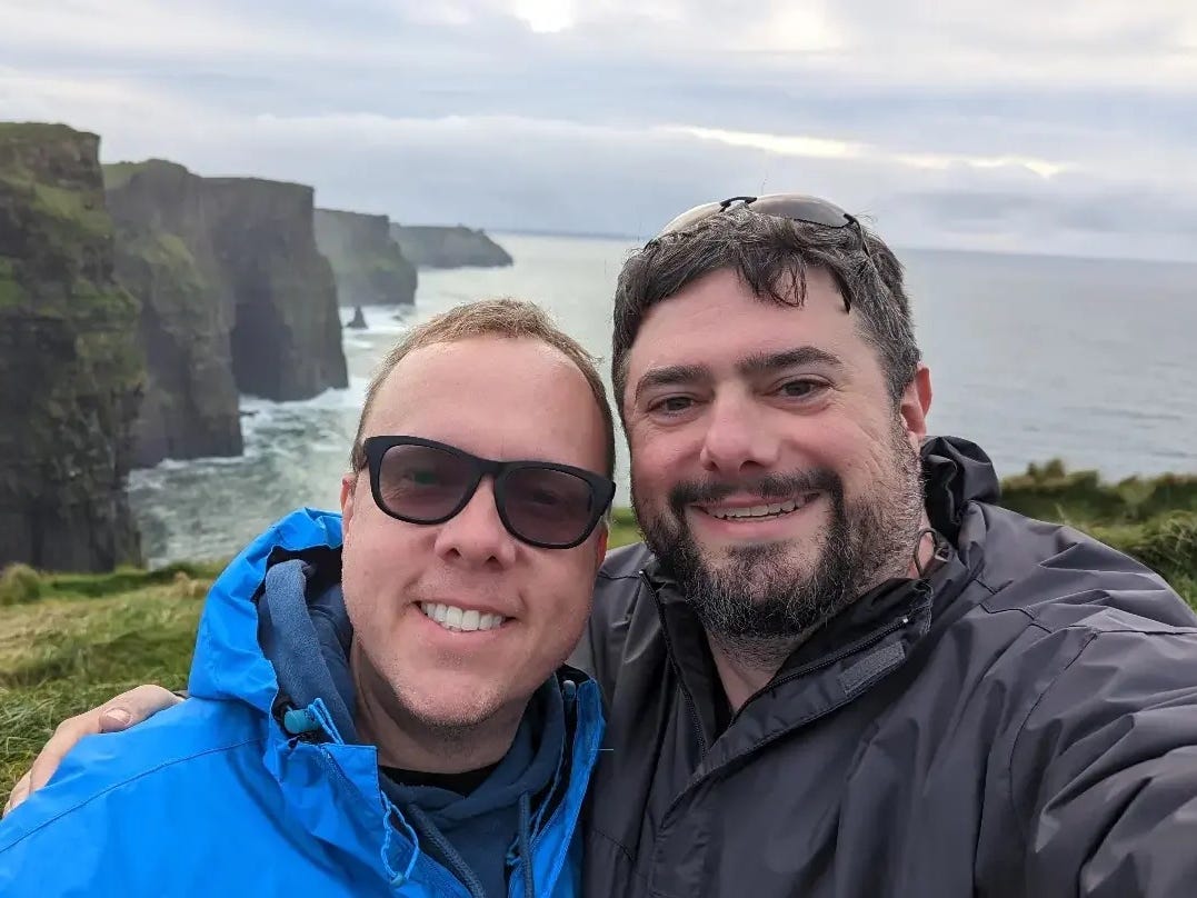 Jason and his husband pose for a photo at the Cliffs of Moher in Ireland.