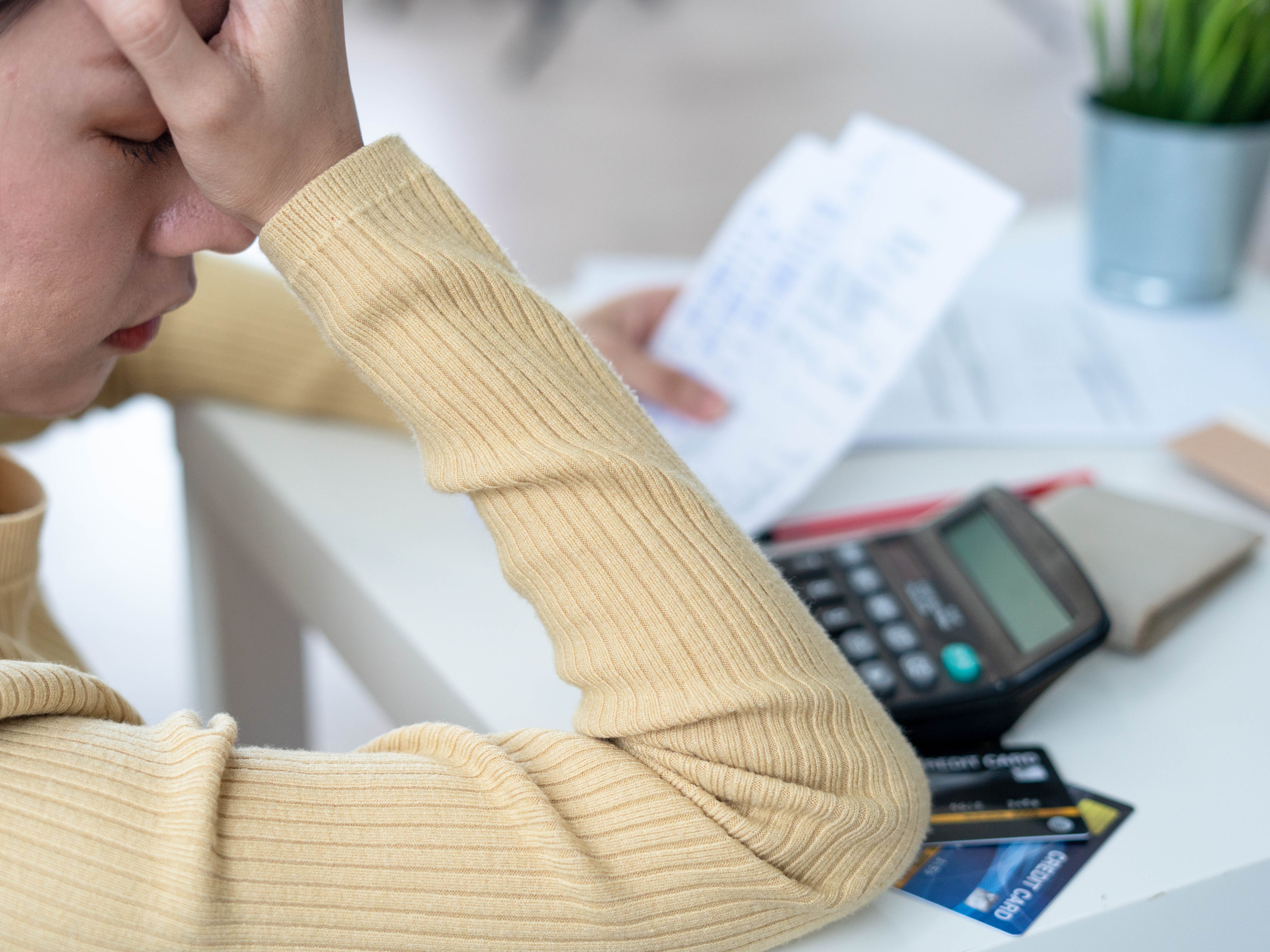 a woman frustrated as she surrounded by credit cards and bills