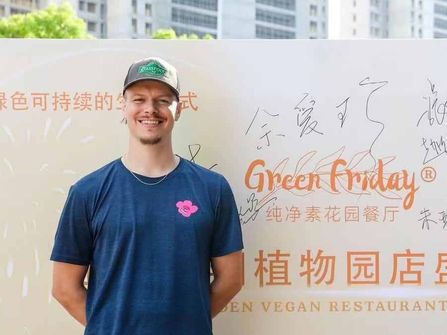 Man standing infront of a sign with Chinese writing.