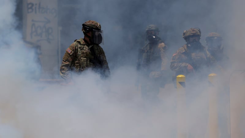 Smoke rises as members of the California National Guard gather during a protest against federal immigration sweeps in downtown Los Angeles.