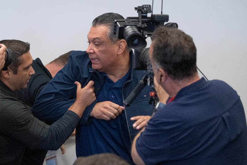 California Senator Alex Padilla is pushed out of the room as Homeland Security Secretary Kristi Noem holds a news conference in Los Angeles on Thursday, June 12, 2025.