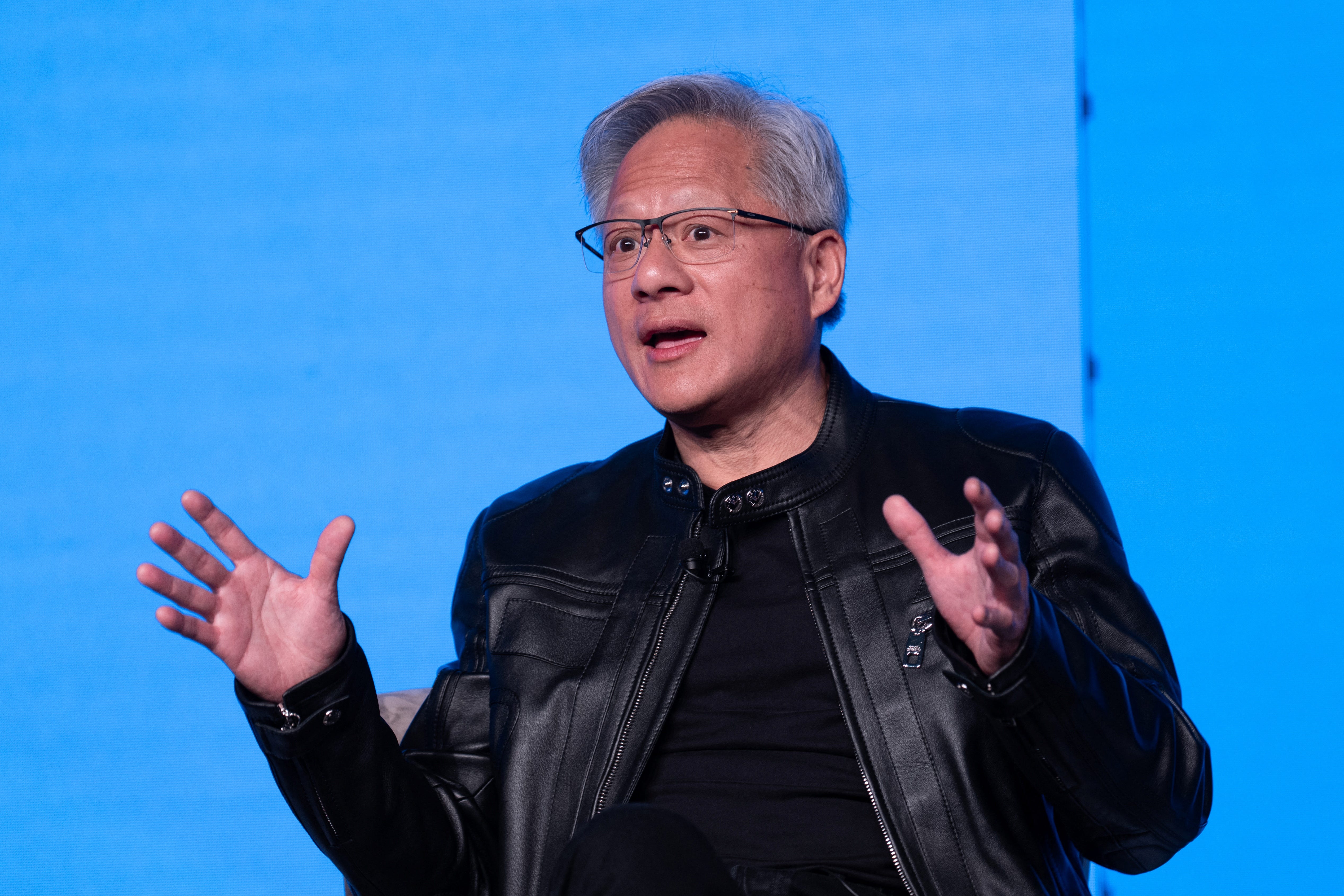 A picture of Jensen Huang with his arms outstretched on stage