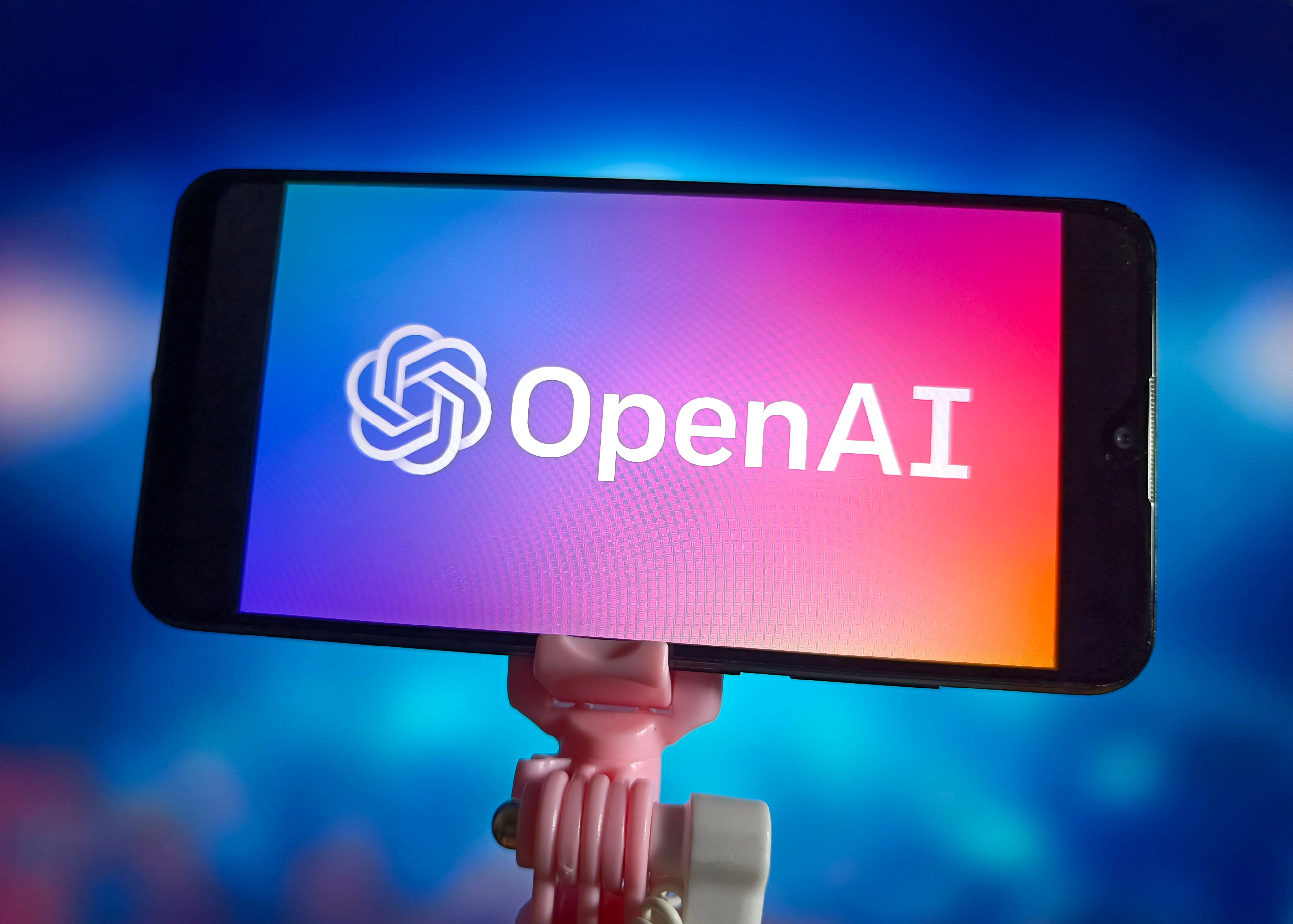OpenAI logo displayed on an iPhone with a blue background