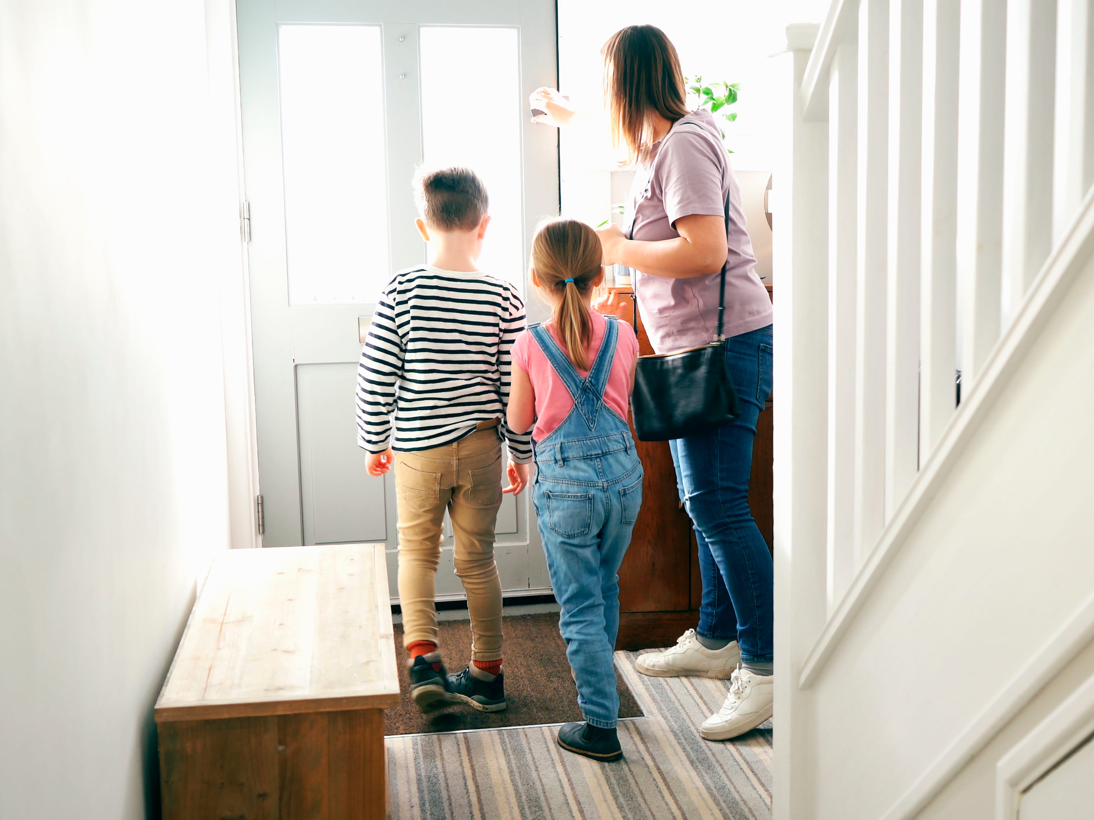 A mom and her two kids leaving their house