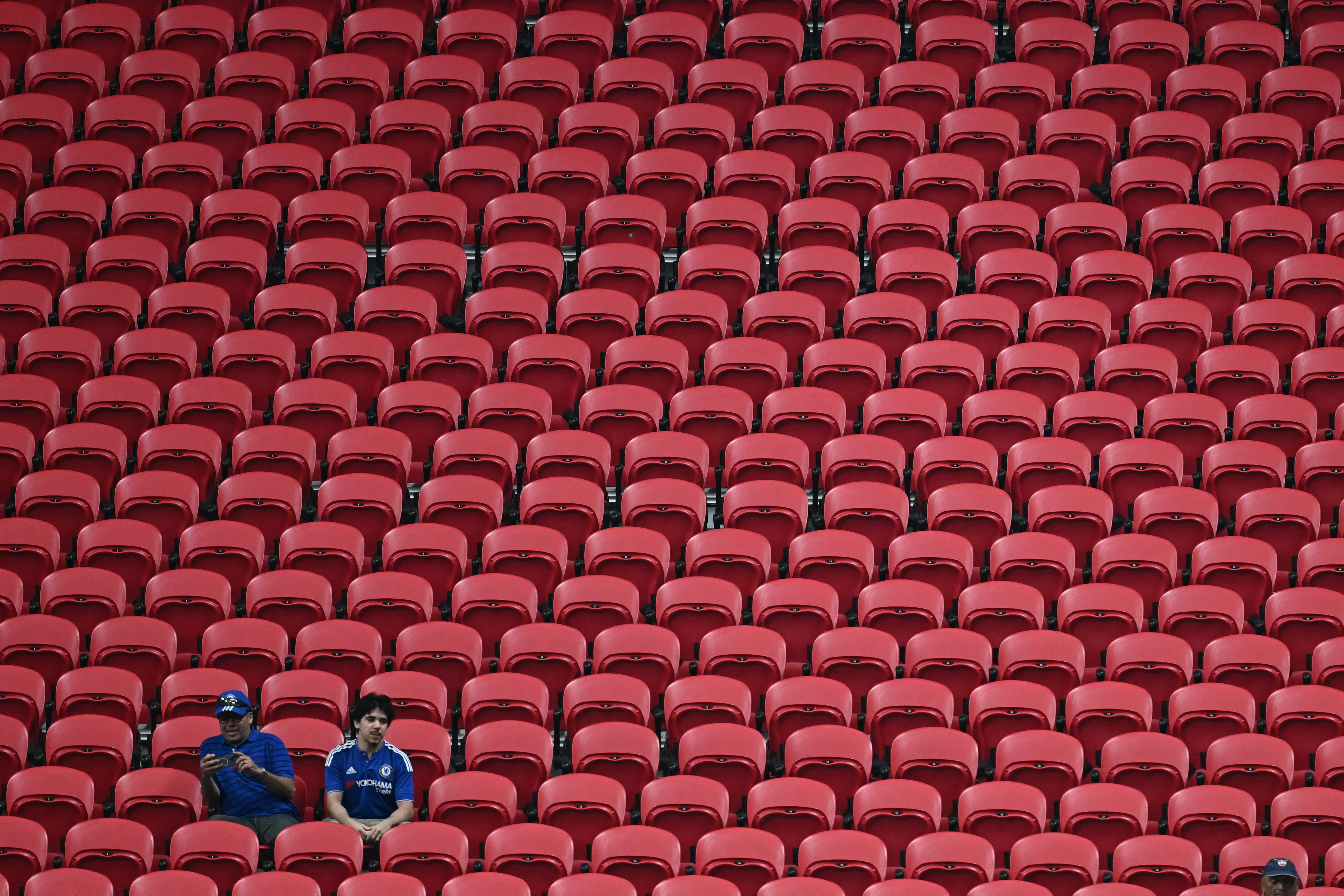 Two Chelsea's supporters sit in an empty tribune during the FIFA Club World Cup 2025 Group D football match between England's Chelsea and US Los Angeles FC at the Mercedes-Benz stadium in Atlanta on June 16, 2025.