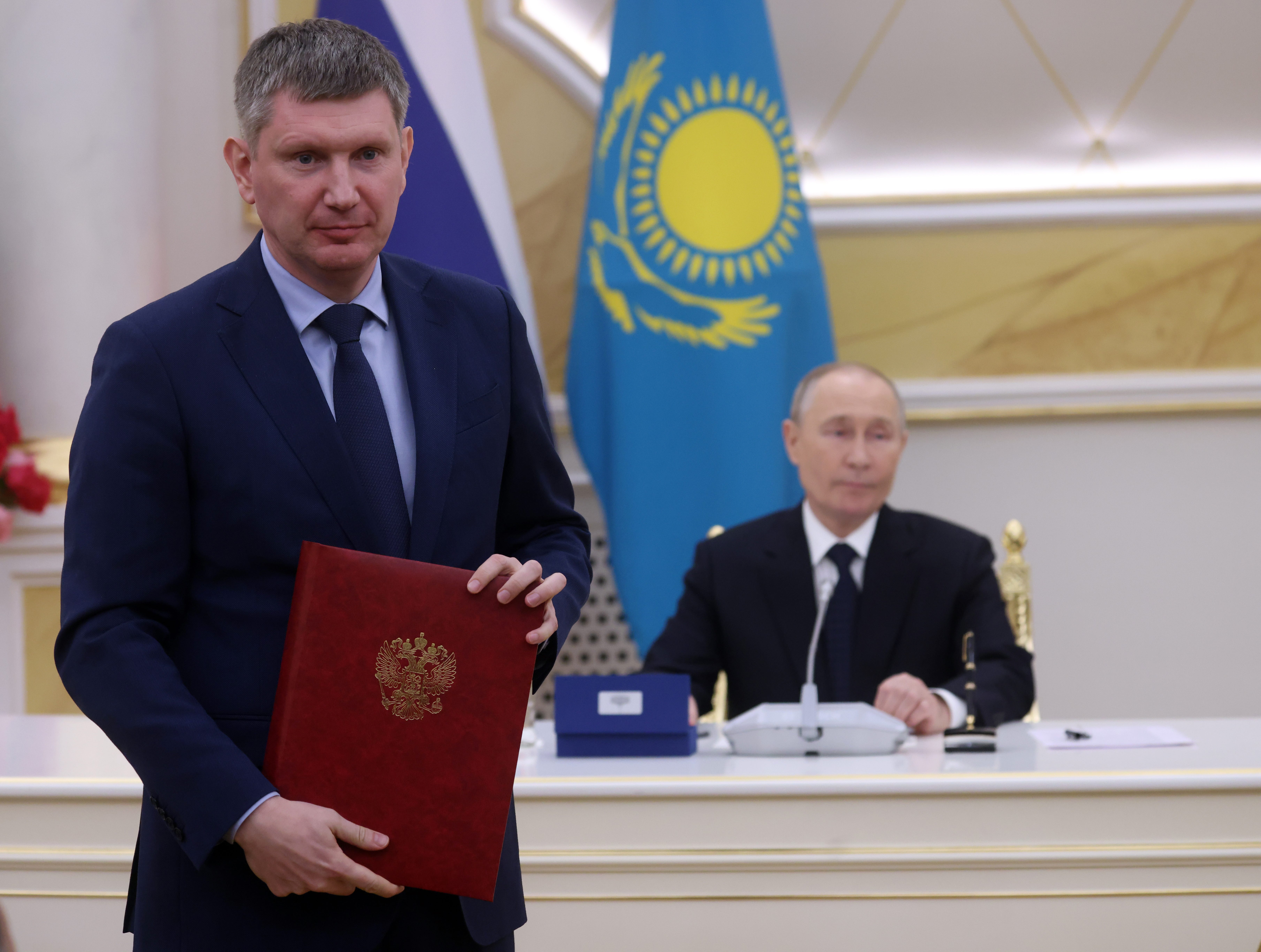 Maxim Reshetnikov, left, and Vladimir Putin, right.