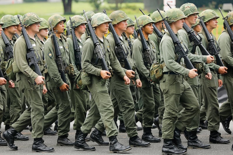 Members of the Army brandish their guns as they march down Washington D.C. for Donald Trump's military parade.