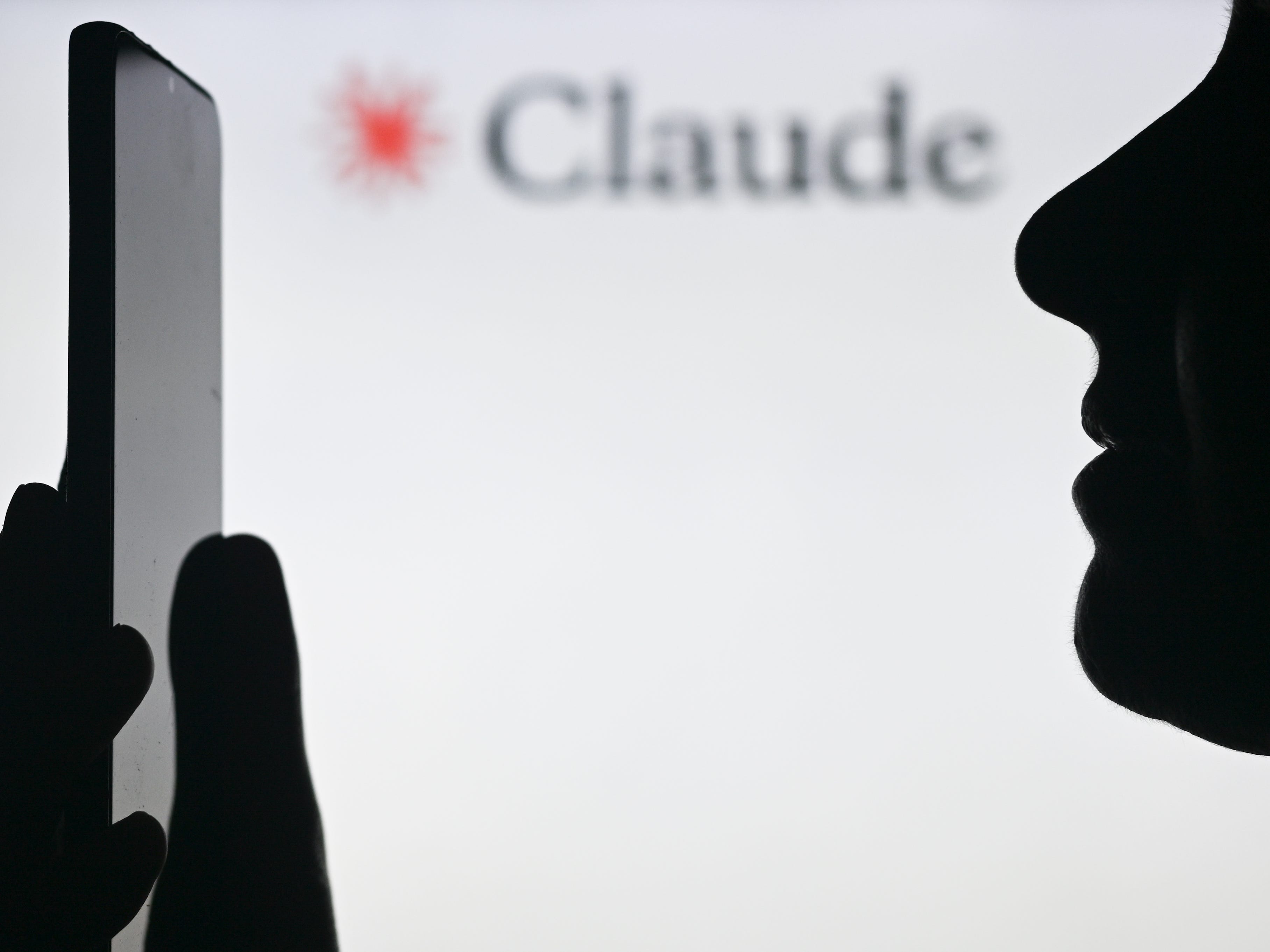 Person reading phone with Claude background