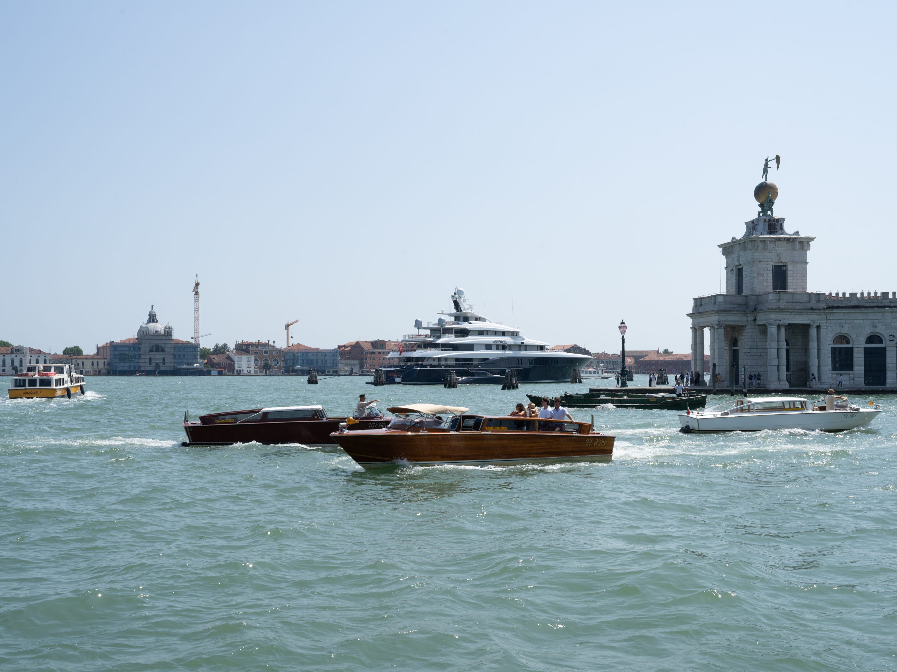 Boats and a Yacht in a Venice canal.