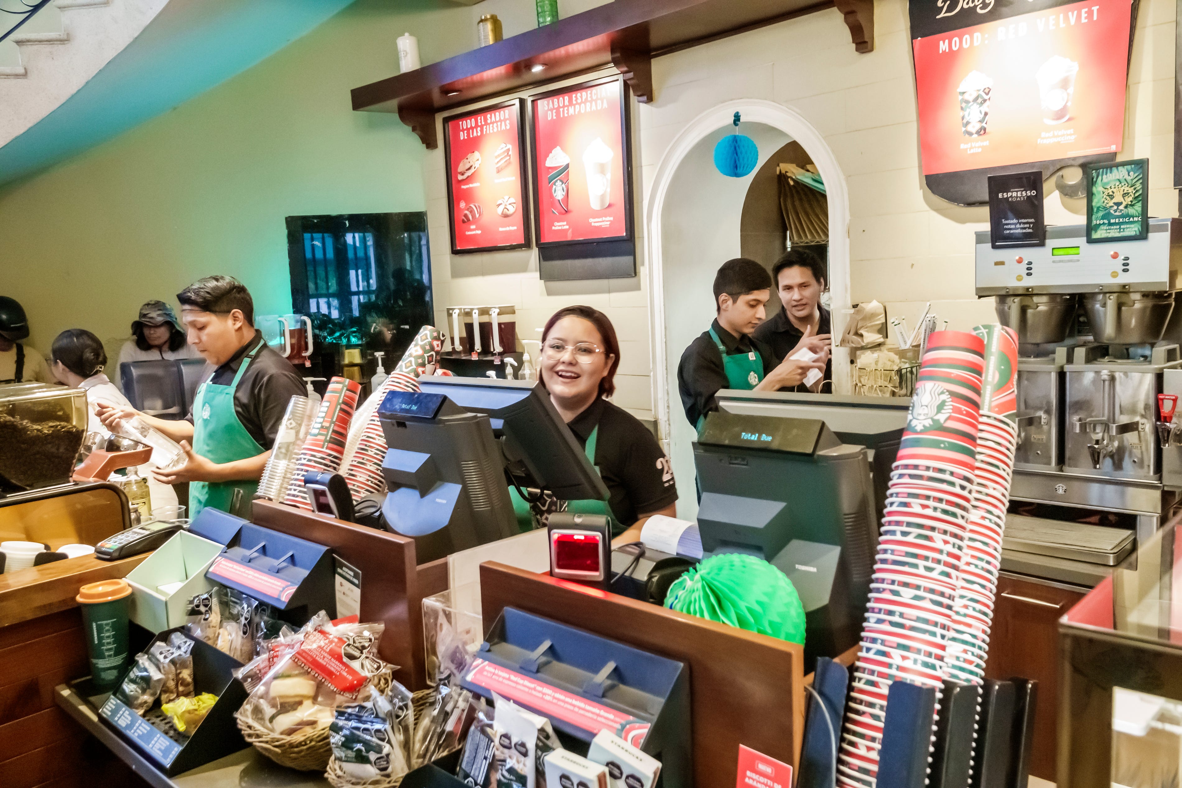 Merida, Mexico, Zona Paseo Montejo Centro, Starbucks Coffee shop, baristas and cashier at work smiling. (
