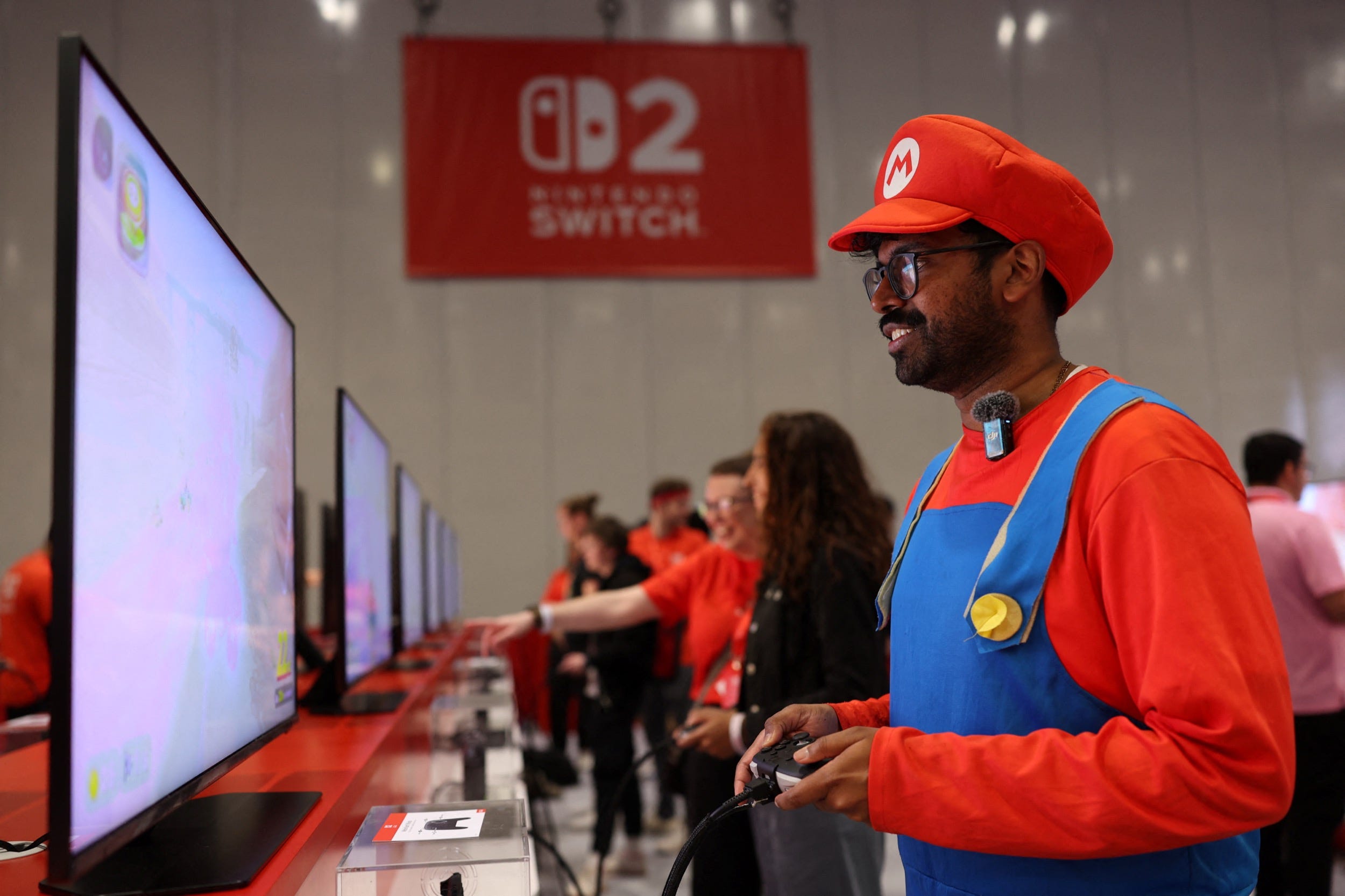 An attendee wearing a Super Mario costume uses a Nintendo Switch 2 game console while playing a video game during the Nintendo Switch 2 Experience at the ExCeL London.